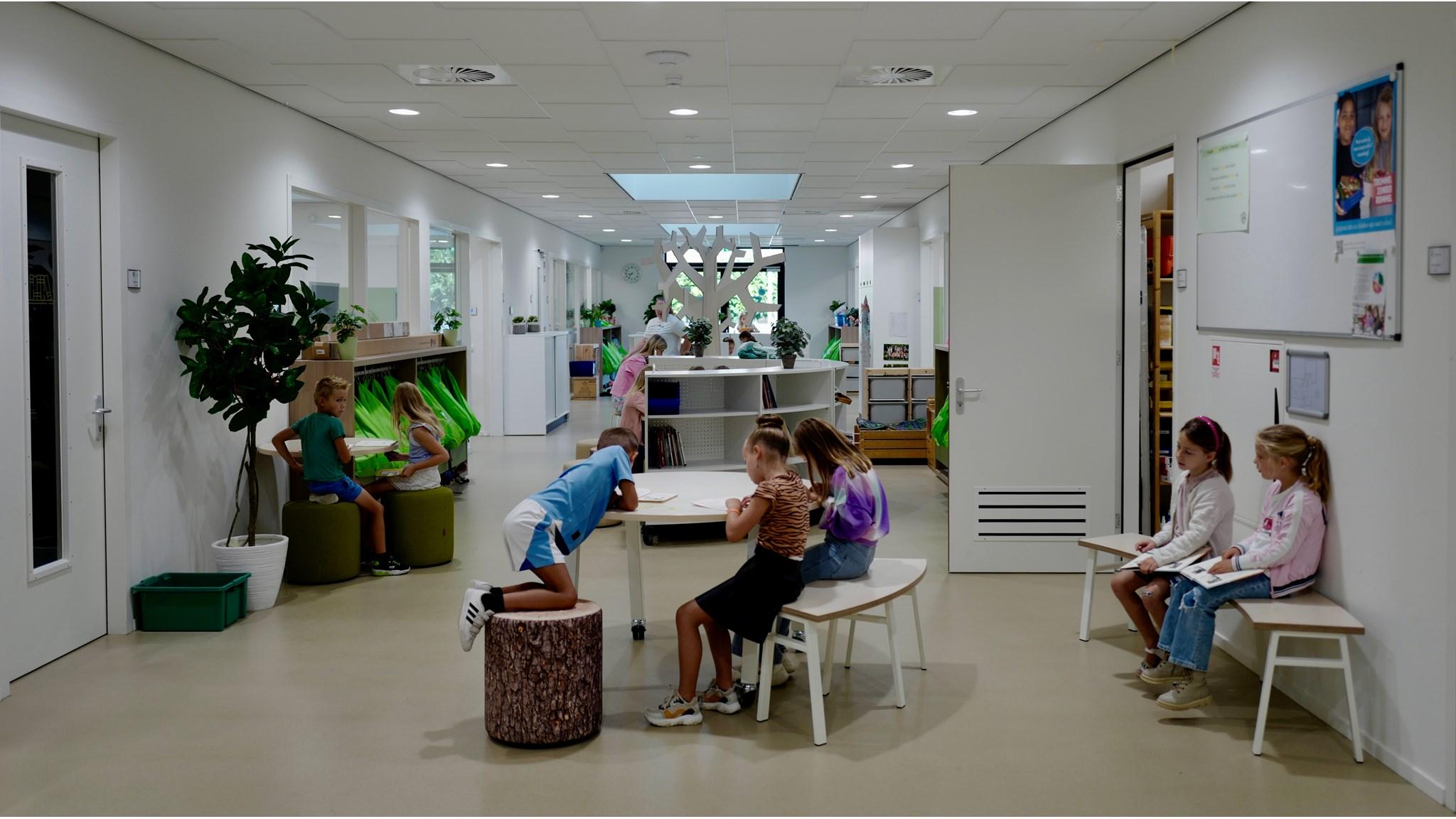 Afbeelding van de interieurinrichting van OBS 'Het Tweespan', locatie Schelluinen, met leerlingen die in een lichte en moderne leeromgeving werken. Afbeelding van de interieurinrichting van OBS 'Het Tweespan', locatie Schelluinen, met leerlingen die in een lichte en moderne leeromgeving werken.