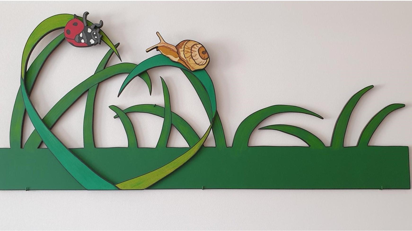 Afbeelding van een creatieve wanddecoratie met gras en insecten bij basisschool De Grasspriet in Valkenswaard. Afbeelding van een creatieve wanddecoratie met gras en insecten bij basisschool De Grasspriet in Valkenswaard.