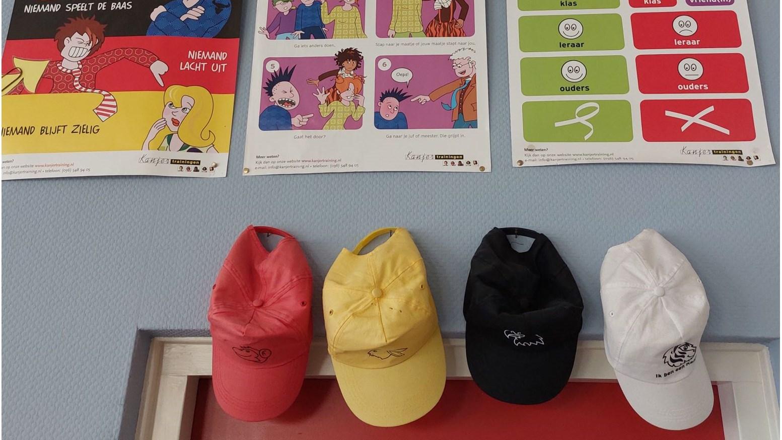 Afbeelding van het klaslokaal van Basisschool De Veste in Waspik met posters en kleurrijke petten aan de muur. Afbeelding van het klaslokaal van Basisschool De Veste in Waspik met posters en kleurrijke petten aan de muur.