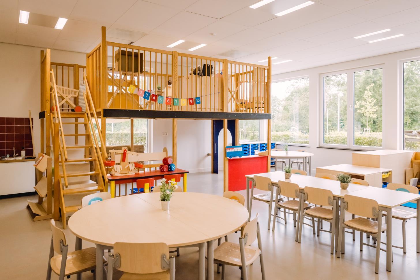 Afbeelding van het leslokaal van Basisschool De Regenboog in Waddinxveen met een speelhoek en tafels voor leerlingen. Afbeelding van het leslokaal van Basisschool De Regenboog in Waddinxveen met een speelhoek en tafels voor leerlingen.