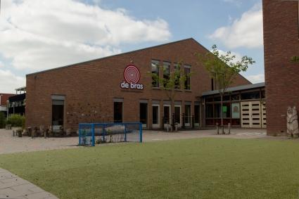 Basisschool De Bras in Den Haag met een groen schoolplein en een moderne gevel.
