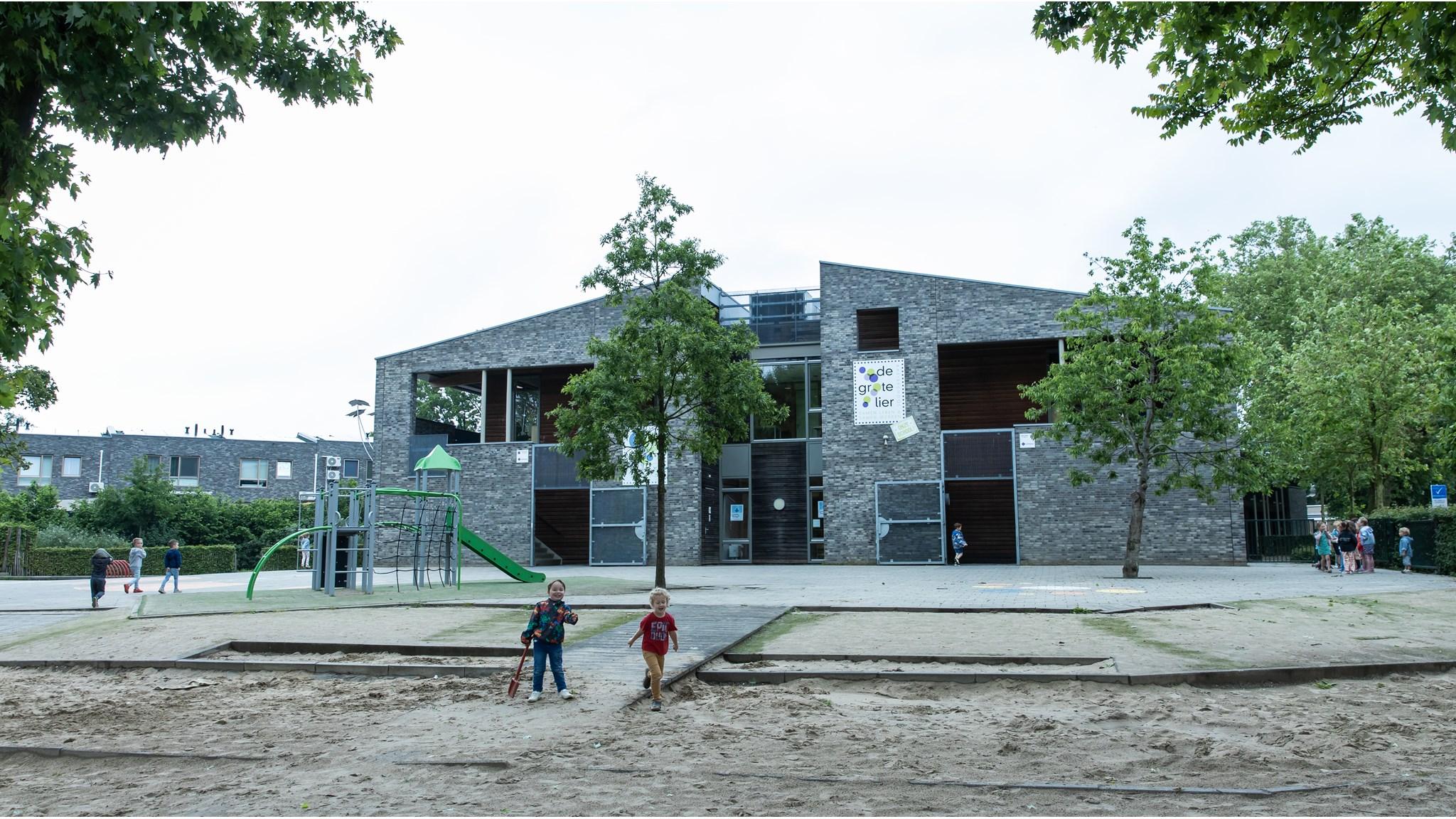 Basisschool De Grote Lier in Molenhoek met een speelplein en kinderen die buiten spelen. Basisschool De Grote Lier in Molenhoek met een speelplein en kinderen die buiten spelen.