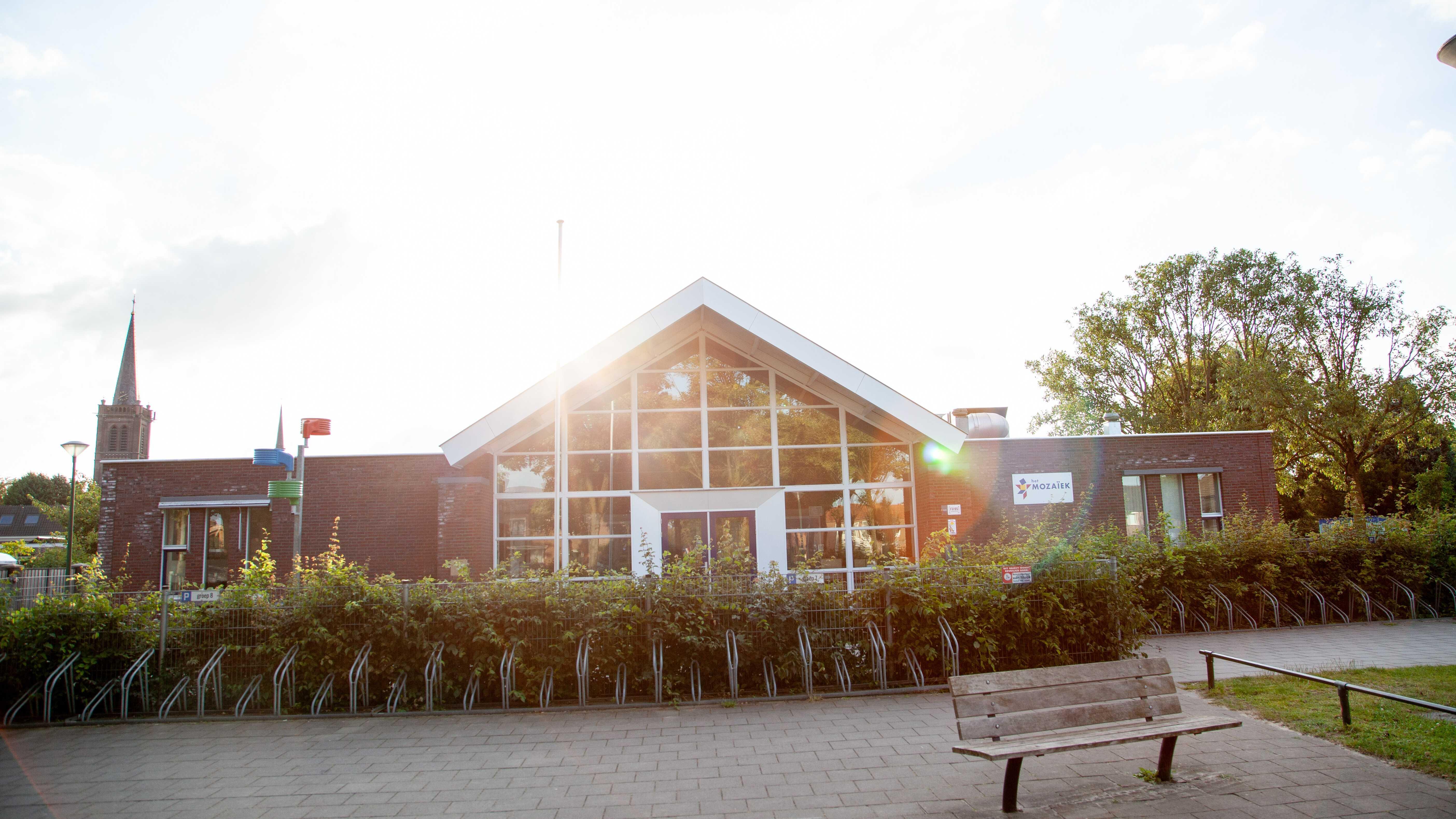 Basisschool het Mozaiek in Heeswijk-Dinther met een zonnige buitenscène. Basisschool het Mozaiek in Heeswijk-Dinther met een zonnige buitenscène.