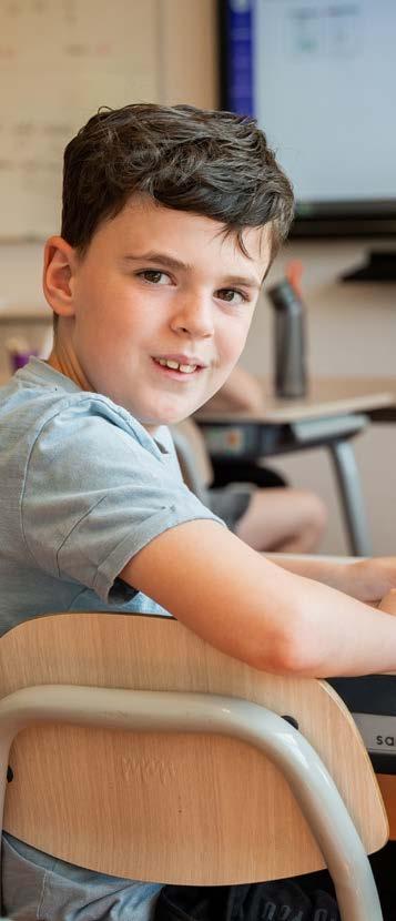 Basisschool Lambertus in Vessem, een leerling die glimlacht terwijl hij aan zijn bureau zit. Basisschool Lambertus in Vessem, een leerling die glimlacht terwijl hij aan zijn bureau zit.