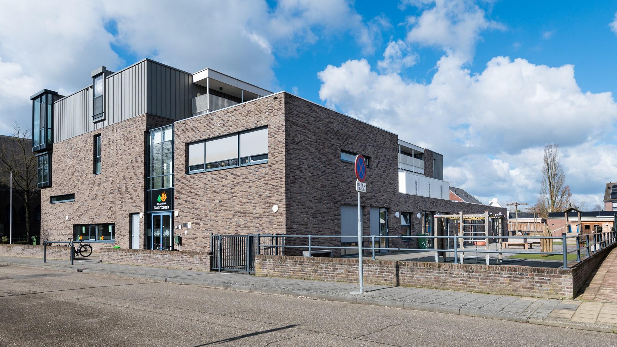 Basisschool Swartbroek in Weert met een modern schoolplein en zonnige blauwe lucht. Basisschool Swartbroek in Weert met een modern schoolplein en zonnige blauwe lucht.