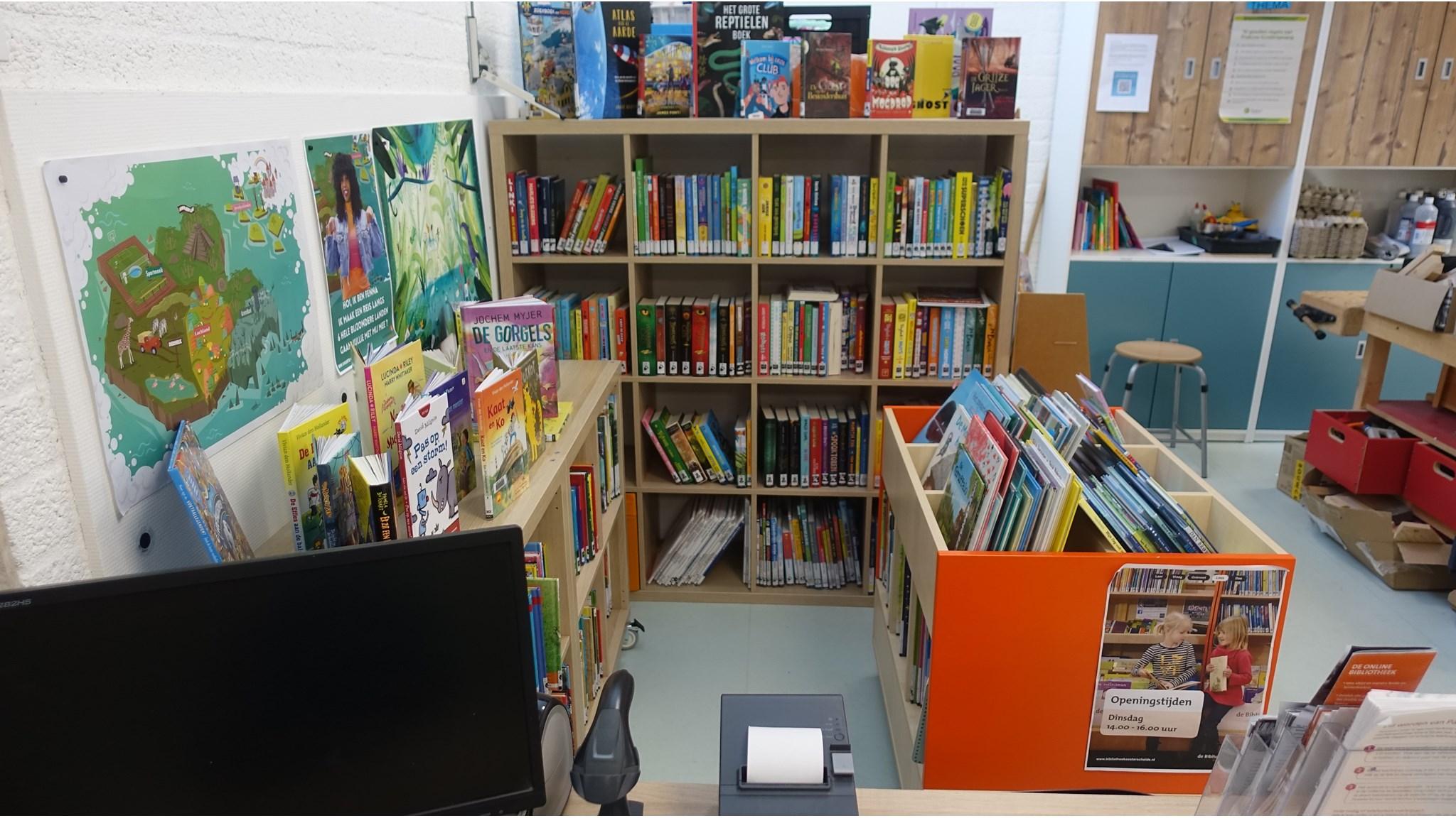 Beeld van de bibliotheek binnen Kindcentrum De Poeljeugd in 's-Heer Hendrikskinderen met boeken en een computer. Beeld van de bibliotheek binnen Kindcentrum De Poeljeugd in 's-Heer Hendrikskinderen met boeken en een computer.