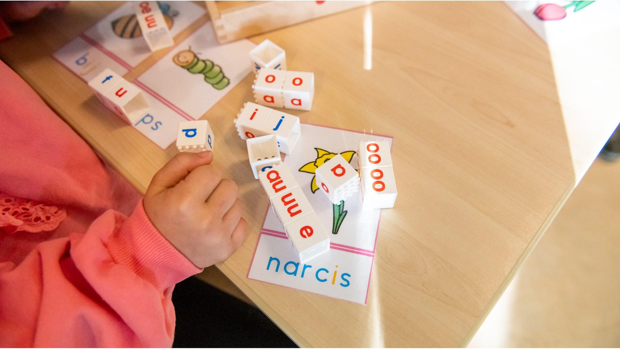 Beeld van een kind dat letters speelt met letterblokjes op Basisschool De Wereldwijzer in Leiden. Beeld van een kind dat letters speelt met letterblokjes op Basisschool De Wereldwijzer in Leiden.