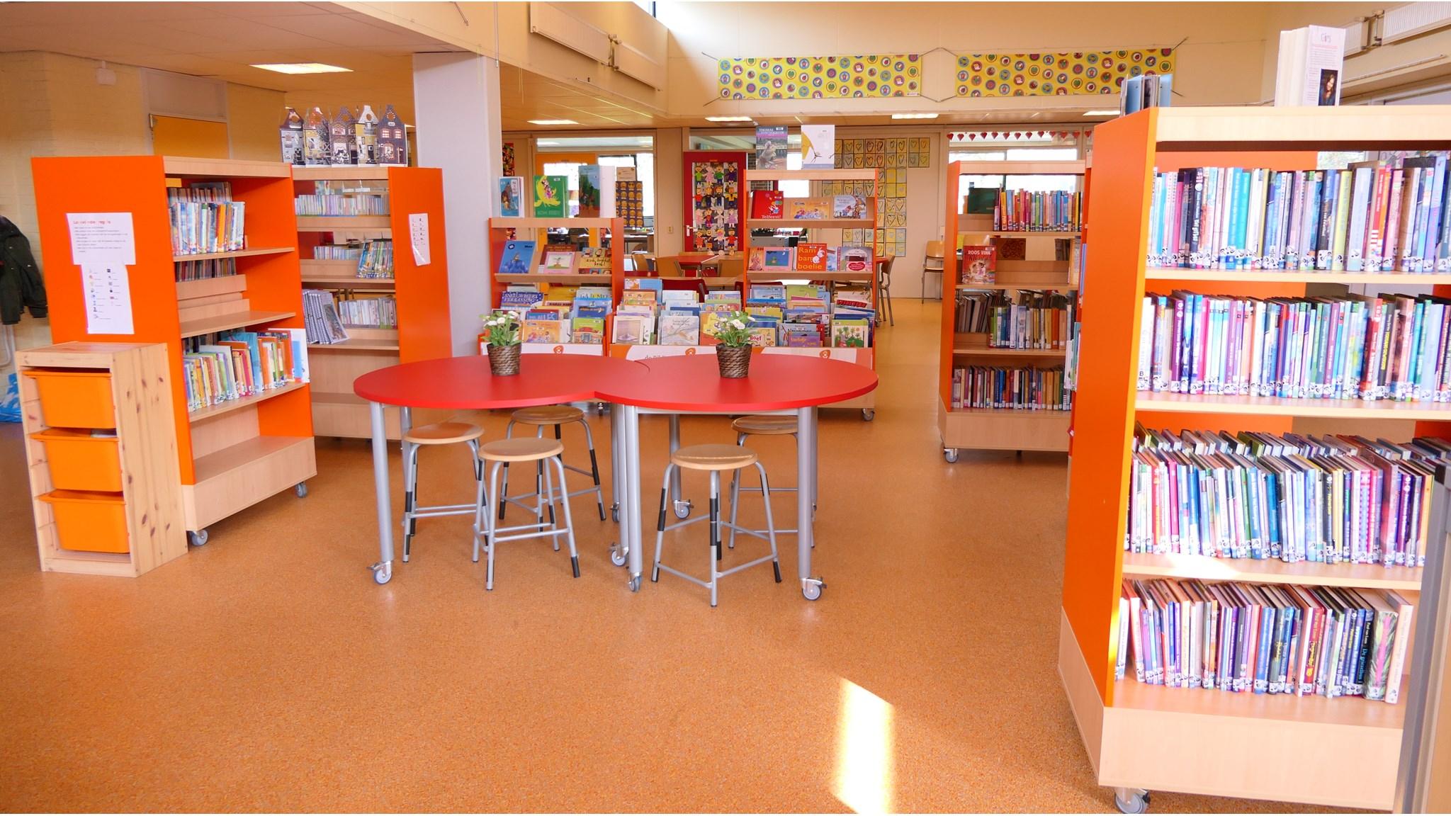 Bibliotheek van IKC Het Groene Hart in Zuidwolde (Drenthe) met kleurrijke boekenplanken en een centraal tafel.