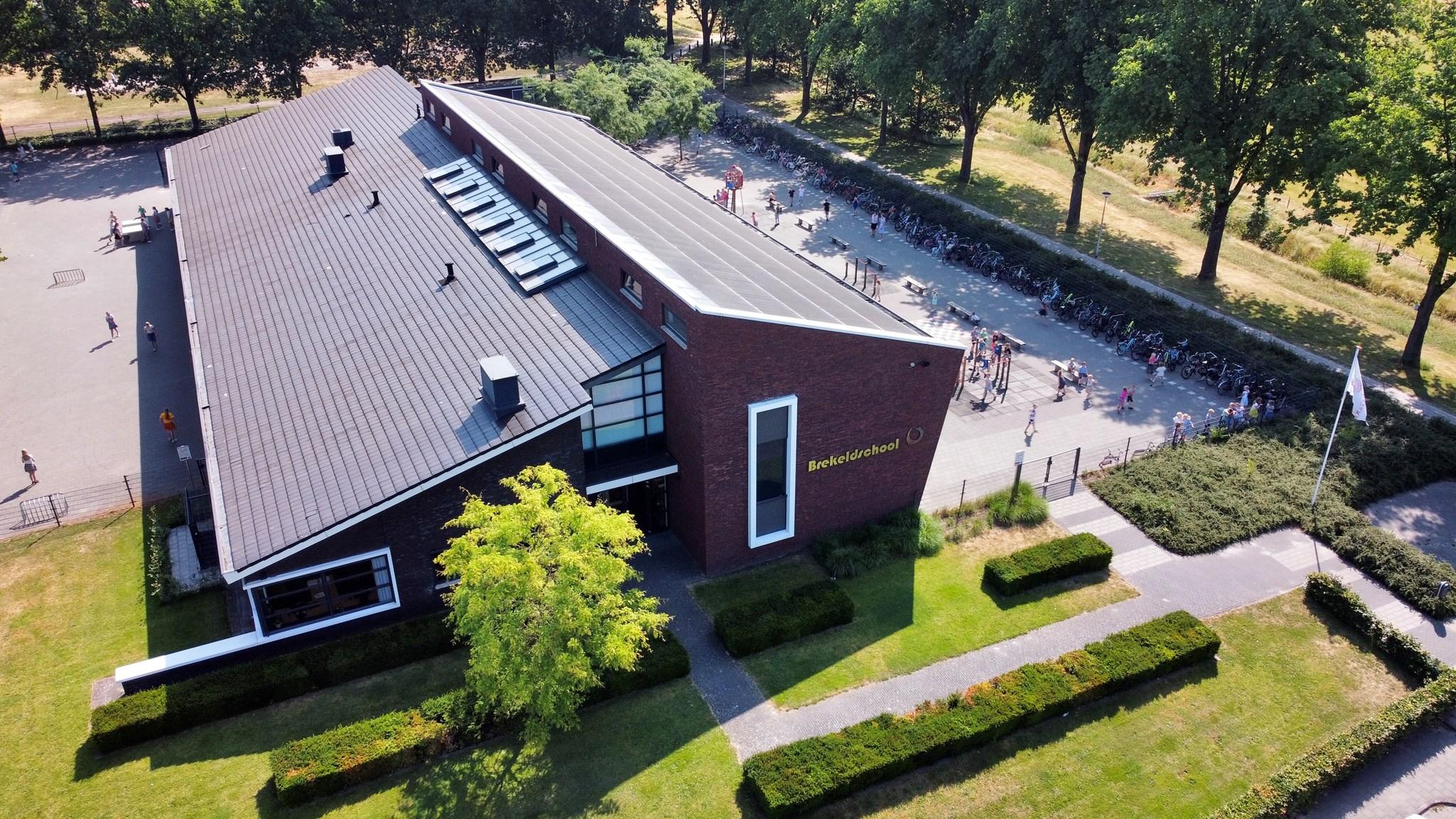 Bovenaanzicht van de Brekeldschool in Rijssen met leerlingen op het schoolplein. Bovenaanzicht van de Brekeldschool in Rijssen met leerlingen op het schoolplein.