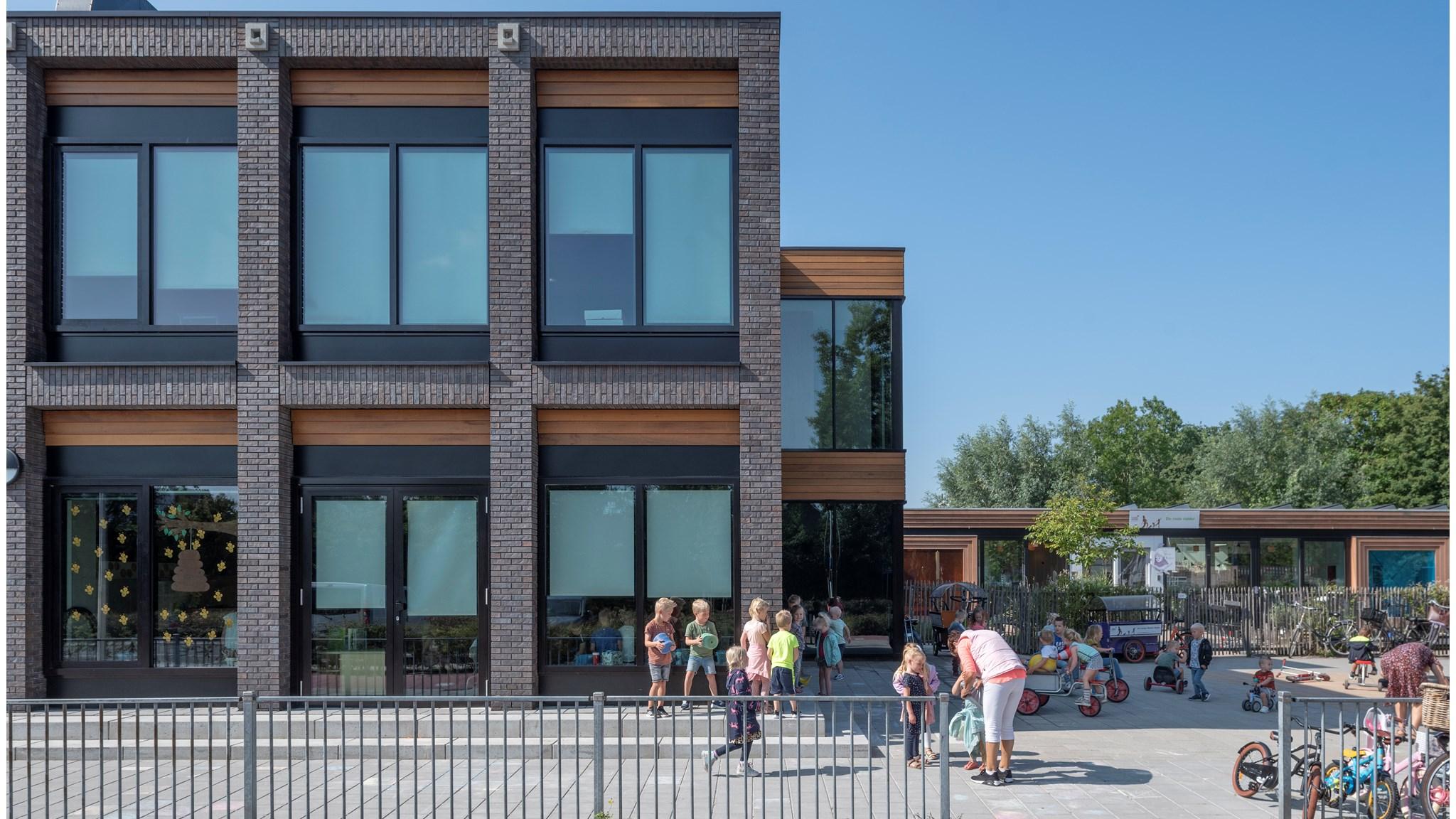 Buitenscène van de R.K. Basisschool WSKO De Achtsprong in De Lier, met kinderen die spelen op het schoolplein. Buitenscène van de R.K. Basisschool WSKO De Achtsprong in De Lier, met kinderen die spelen op het schoolplein.