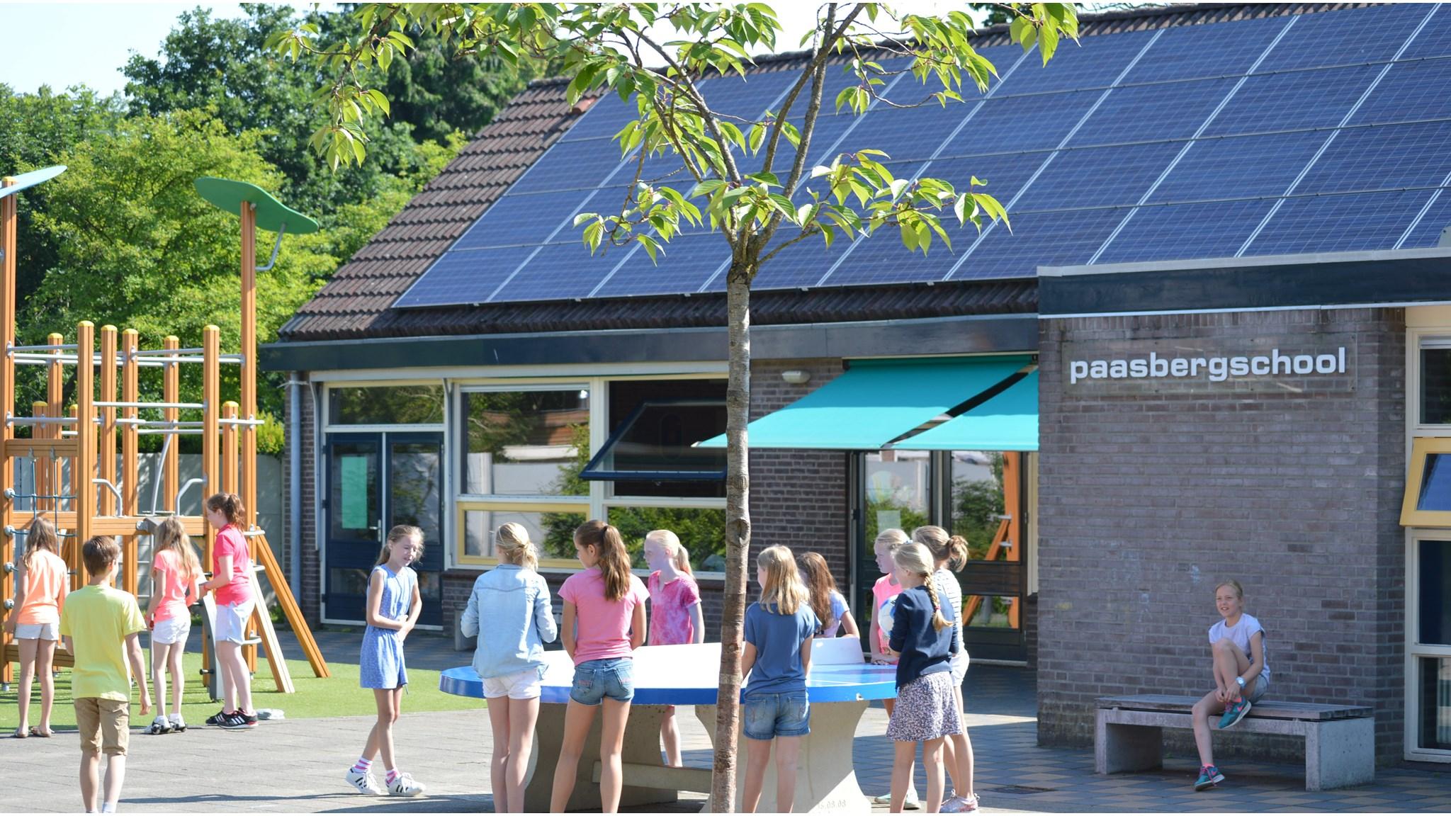 Buitenspeelplaats van basisschool de Paasberg in Oosterbeek met spelende kinderen.