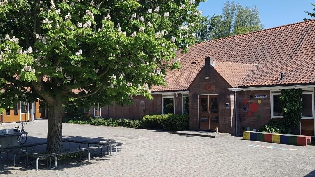 De buitenkant van de Rooms Katholieke basisschool St. Willibrordus, gelegen in Buitenkaag, met een groene boom en een zonnig schoolplein. De buitenkant van de Rooms Katholieke basisschool St. Willibrordus, gelegen in Buitenkaag, met een groene boom en een zonnig schoolplein.
