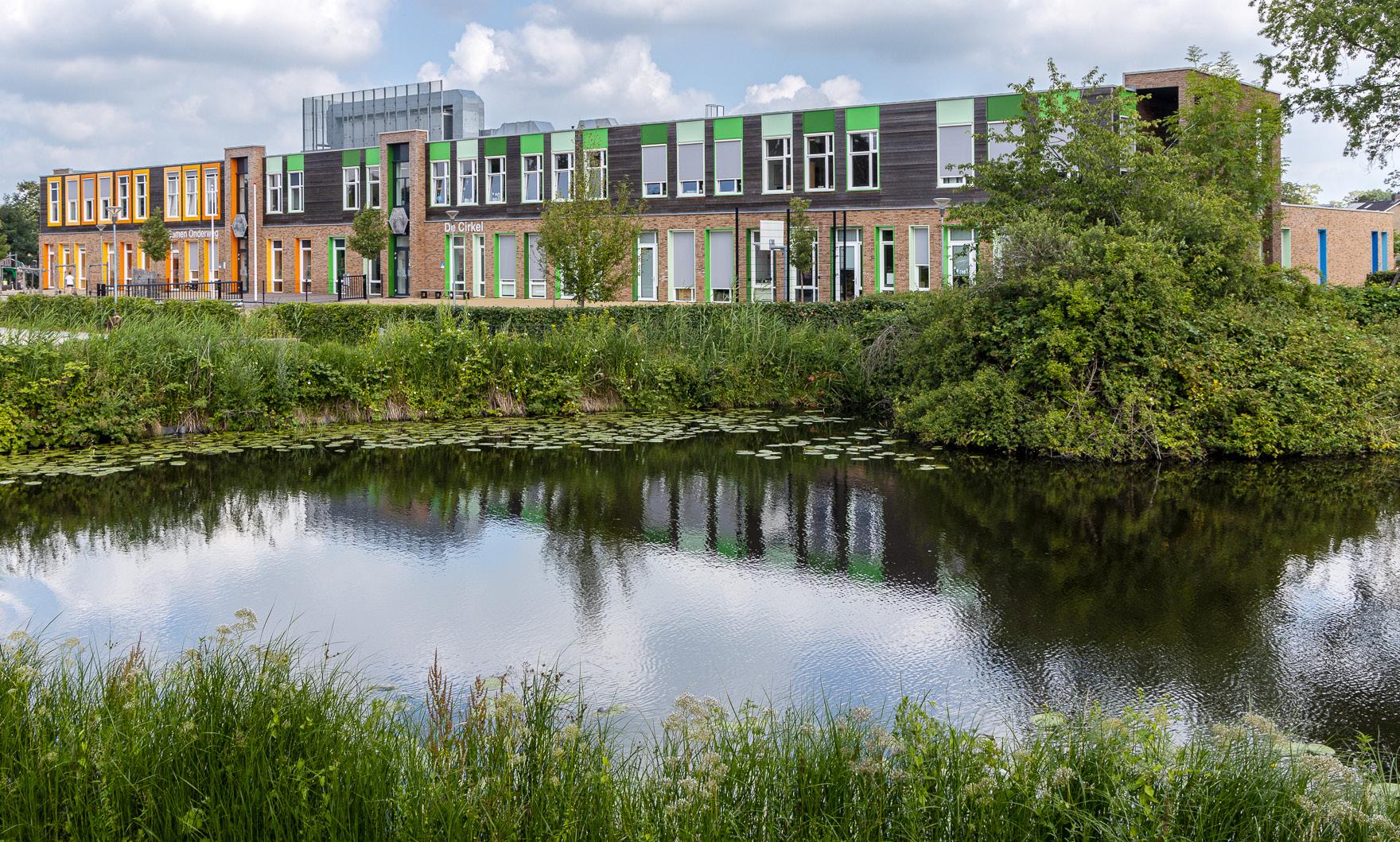 De Cirkel Christelijk Onderwijs ZML in Gorinchem, met uitzicht op het groene schoolplein en de vijver.