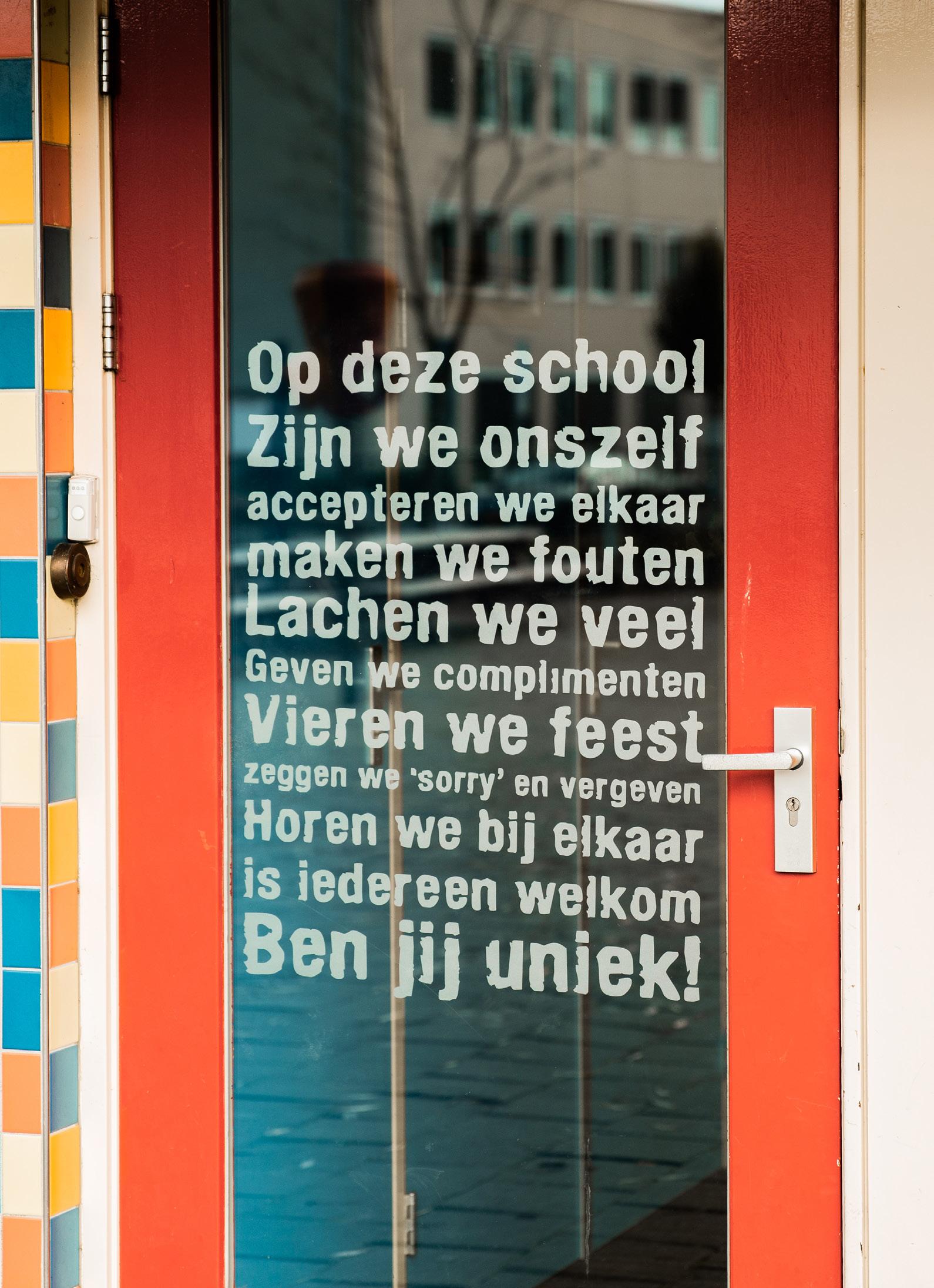 "De deur van de Paasbergschool in Ede met inspirerende teksten over acceptatie en saamhorigheid."