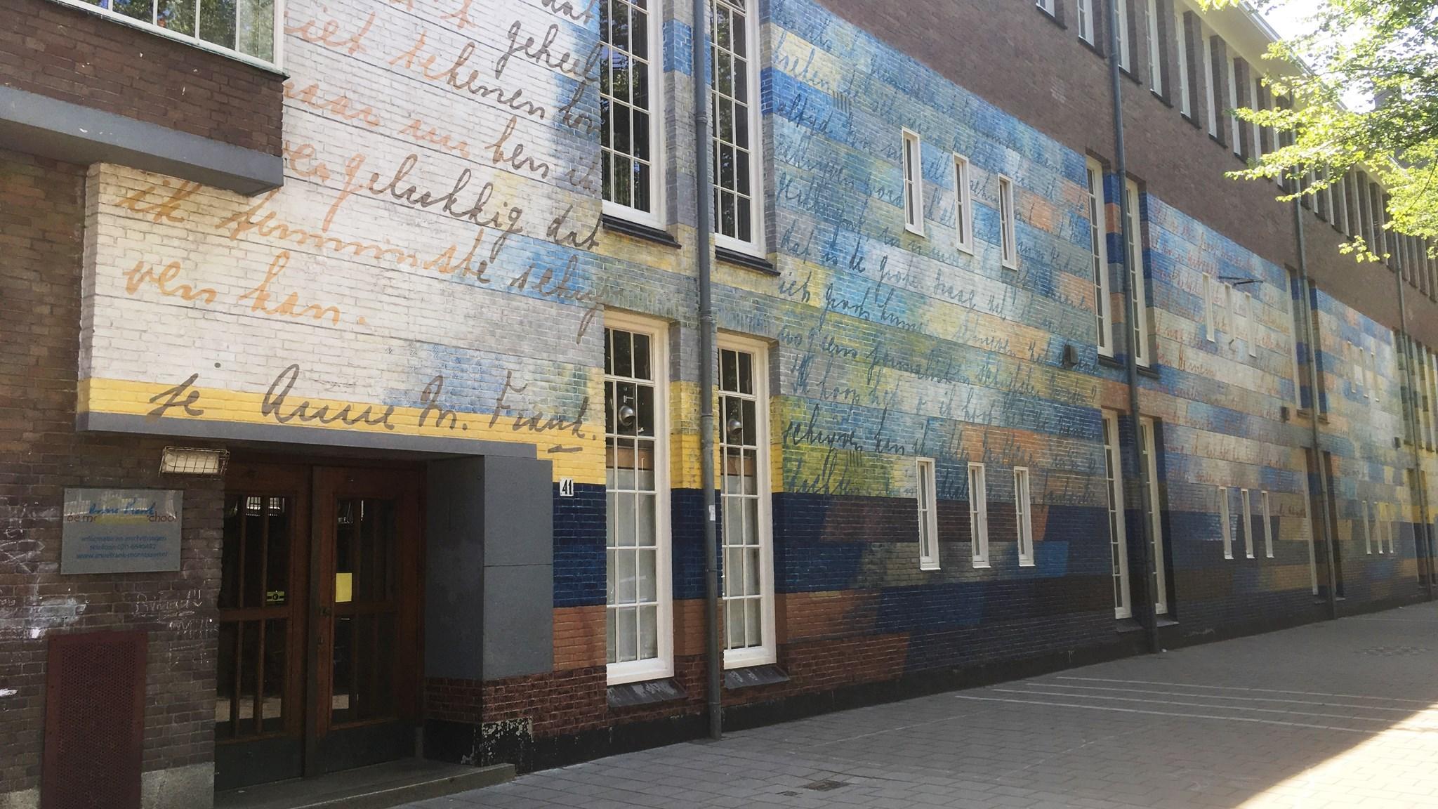 De gevel van Basisschool Anne Frank 6e Montessori-School in Amsterdam, met kleurrijke muurschilderingen en teksten. De gevel van Basisschool Anne Frank 6e Montessori-School in Amsterdam, met kleurrijke muurschilderingen en teksten.