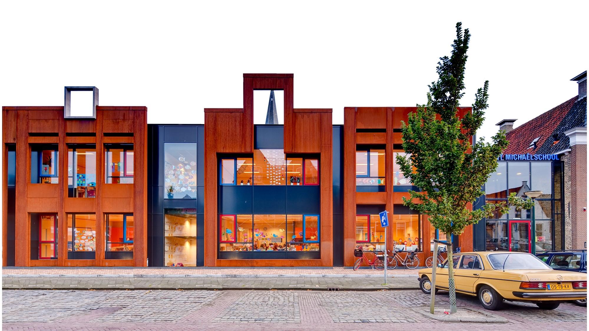 De gevel van basisschool Sint Michael in Harlingen met kleurrijke ramen en een moderne uitstraling. De gevel van basisschool Sint Michael in Harlingen met kleurrijke ramen en een moderne uitstraling.
