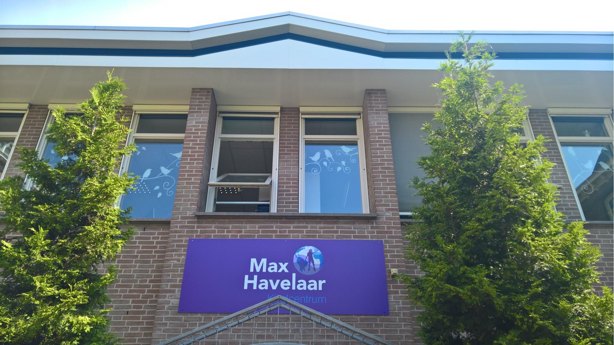 De gevel van het Max Havelaar Kindcentrum in Delft met zicht op de ramen en de kleurrijke schoolbord. De gevel van het Max Havelaar Kindcentrum in Delft met zicht op de ramen en de kleurrijke schoolbord.