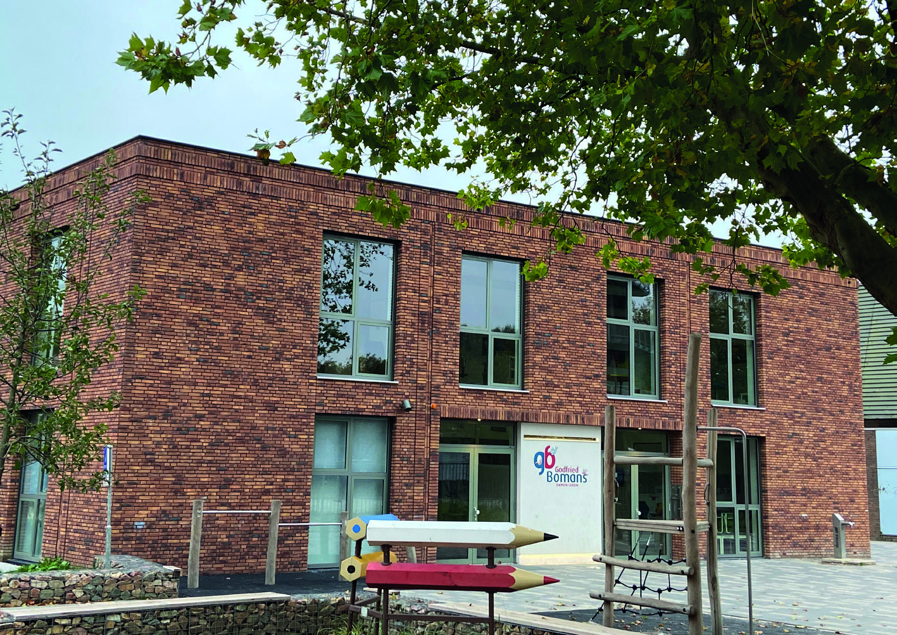De Godfried Bomansschool in Rijswijk met een modern gebouw en een speelse schoolplein.