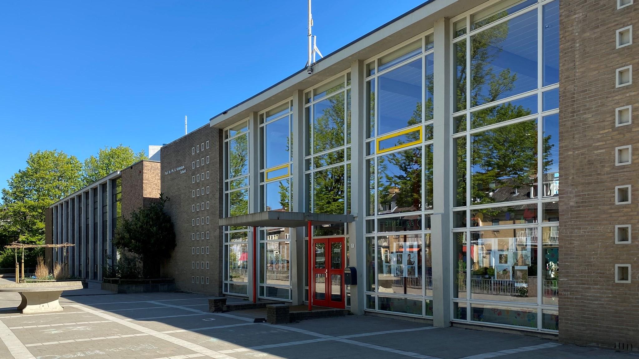 De hoofdingang van de Prof. Kohnstammschool in Utrecht met moderne architectuur en een heldere lucht.