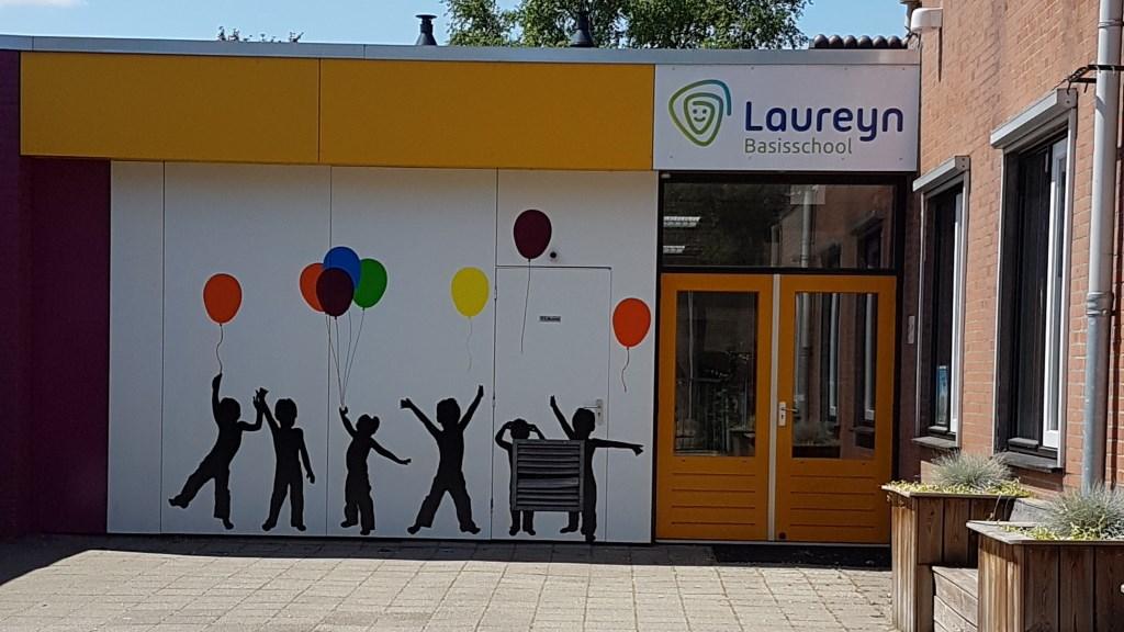 De ingang van Basisschool Laureyn in Philippine met kleurrijke ballonnen en silhouetten van spelende kinderen. De ingang van Basisschool Laureyn in Philippine met kleurrijke ballonnen en silhouetten van spelende kinderen.