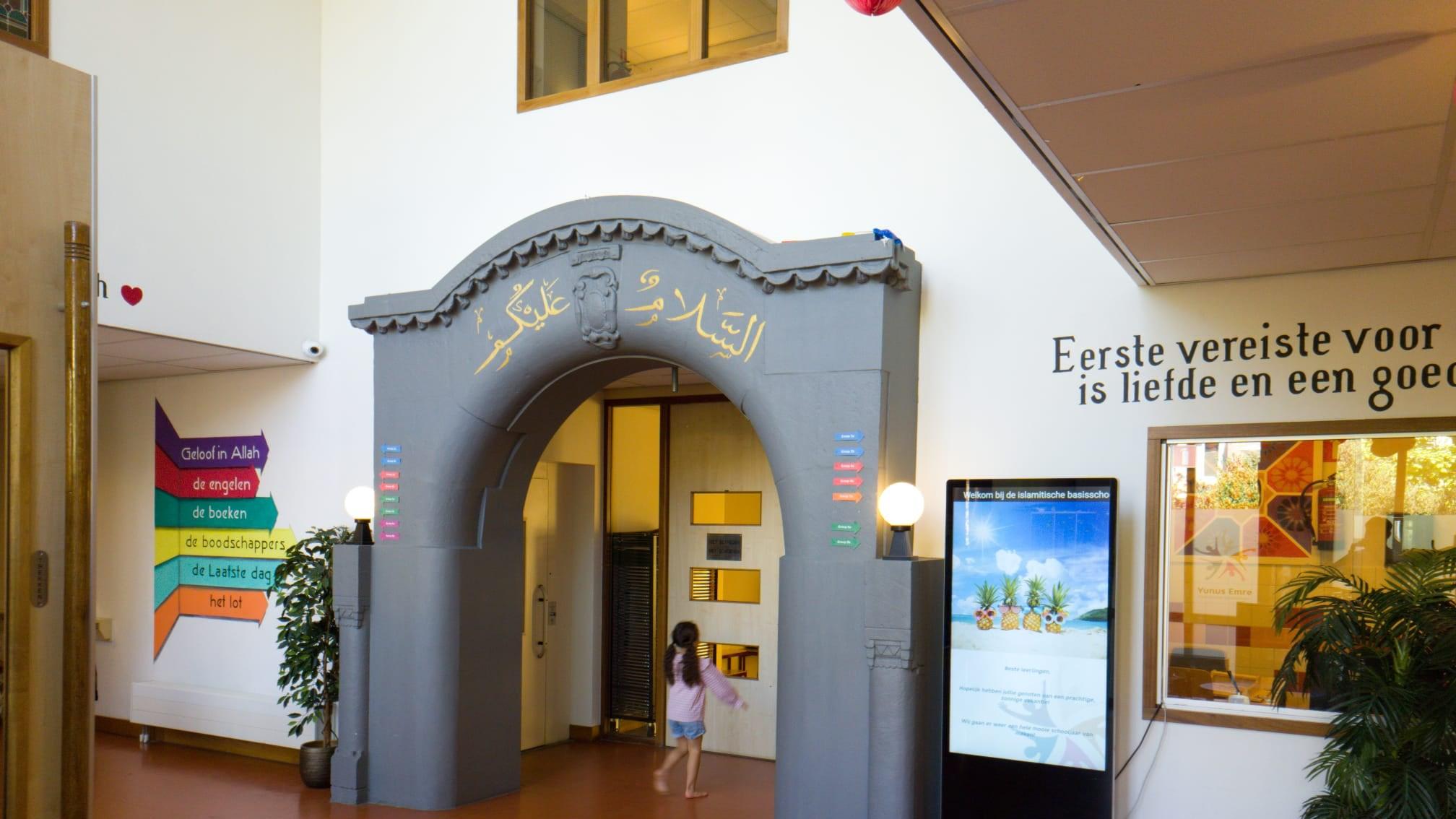 De ingang van de Islamitische Basisschool Yunus Emre in Den Haag, met decoratieve elementen en een kind dat naar binnen loopt. De ingang van de Islamitische Basisschool Yunus Emre in Den Haag, met decoratieve elementen en een kind dat naar binnen loopt.