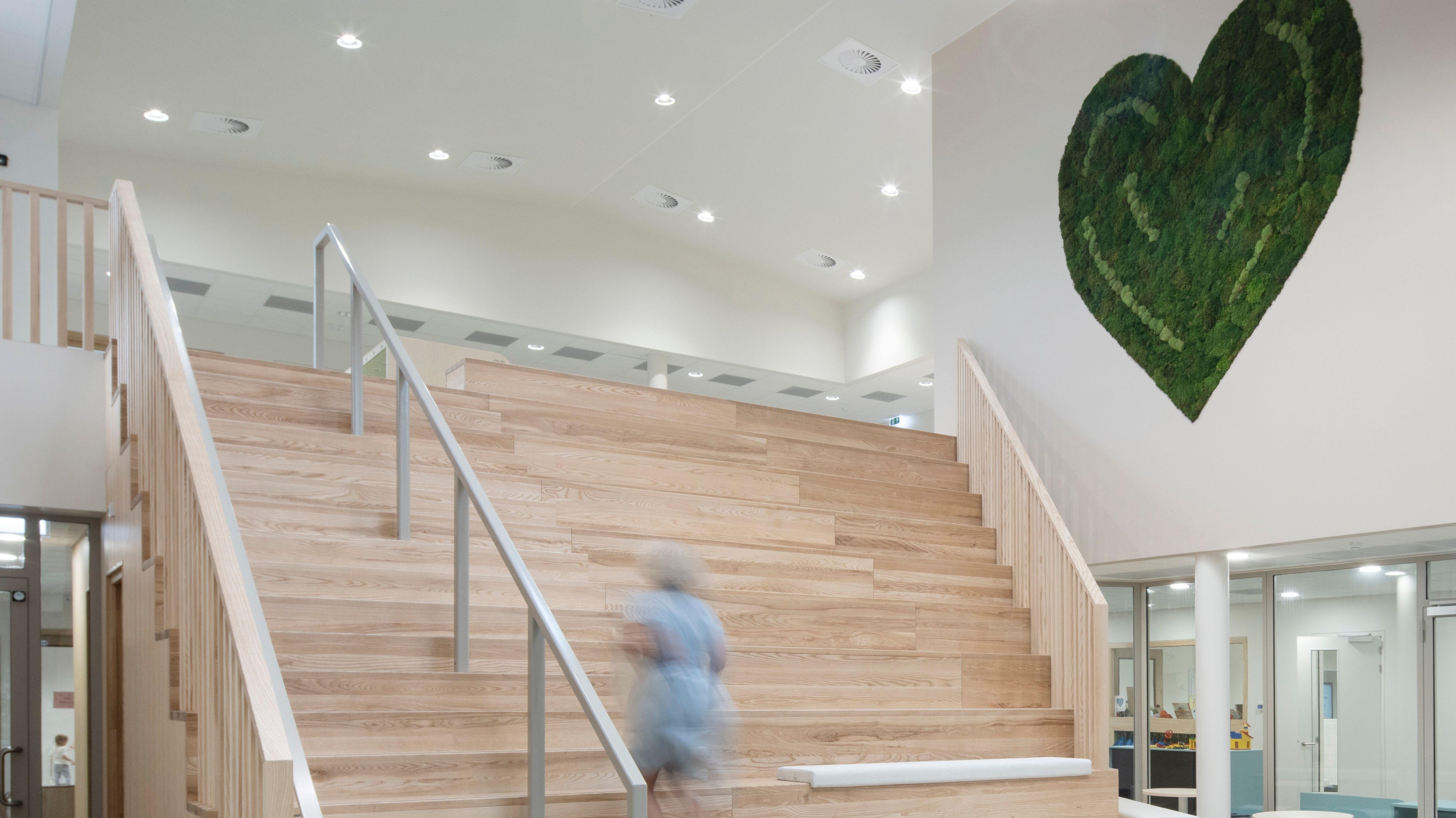 De ingang van de Van Harte School in Houten met een trap en een groene hartdecoratie aan de muur. De ingang van de Van Harte School in Houten met een trap en een groene hartdecoratie aan de muur.