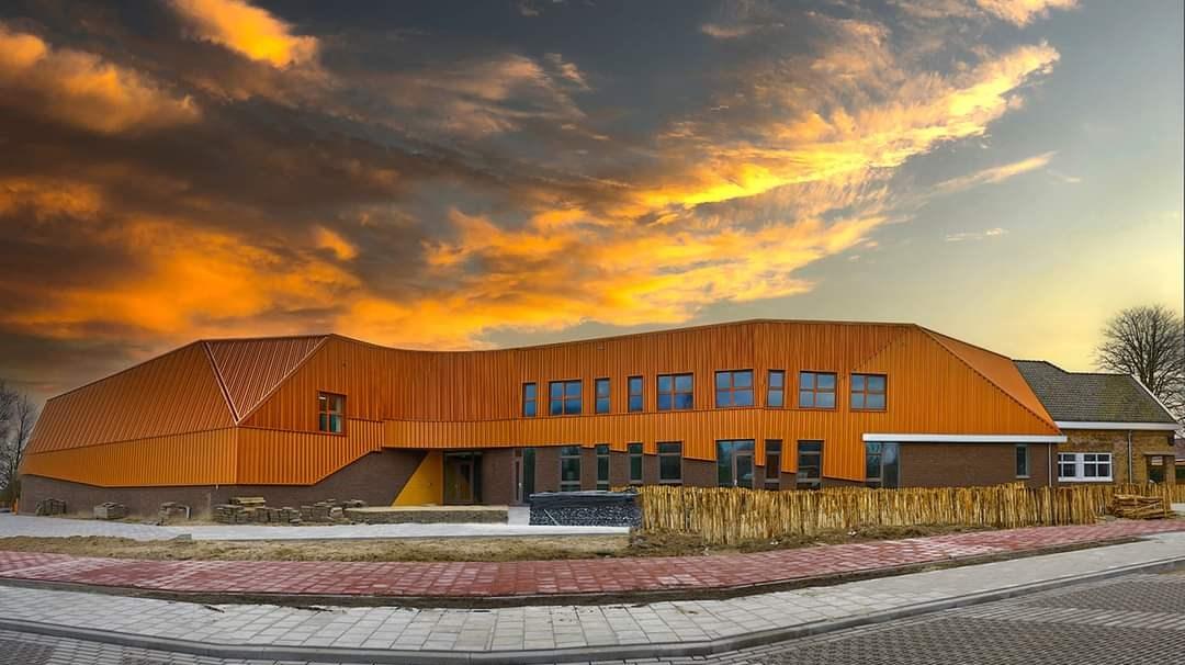 De Jozefschool Texel in Den Burg met een opvallende oranje gevel onder een kleurrijke lucht. De Jozefschool Texel in Den Burg met een opvallende oranje gevel onder een kleurrijke lucht.