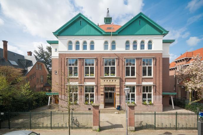 De Kralingsche School voor Basisonderwijs in Rotterdam, met een prachtige gevel en groene dakspanten. De Kralingsche School voor Basisonderwijs in Rotterdam, met een prachtige gevel en groene dakspanten.