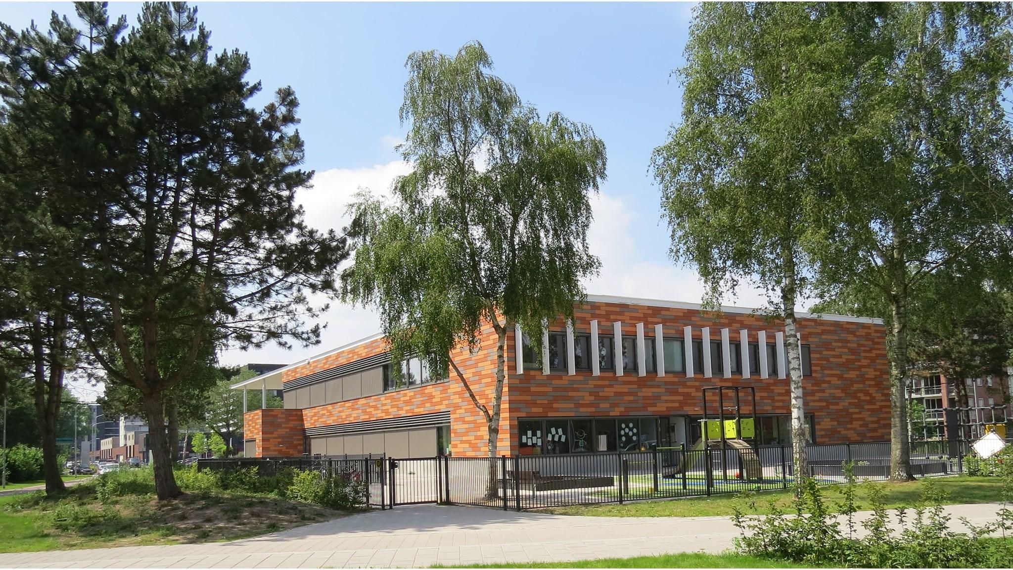 De Kubus in Emmen, met een mooi schoolplein en omringd door groen. De Kubus in Emmen, met een mooi schoolplein en omringd door groen.