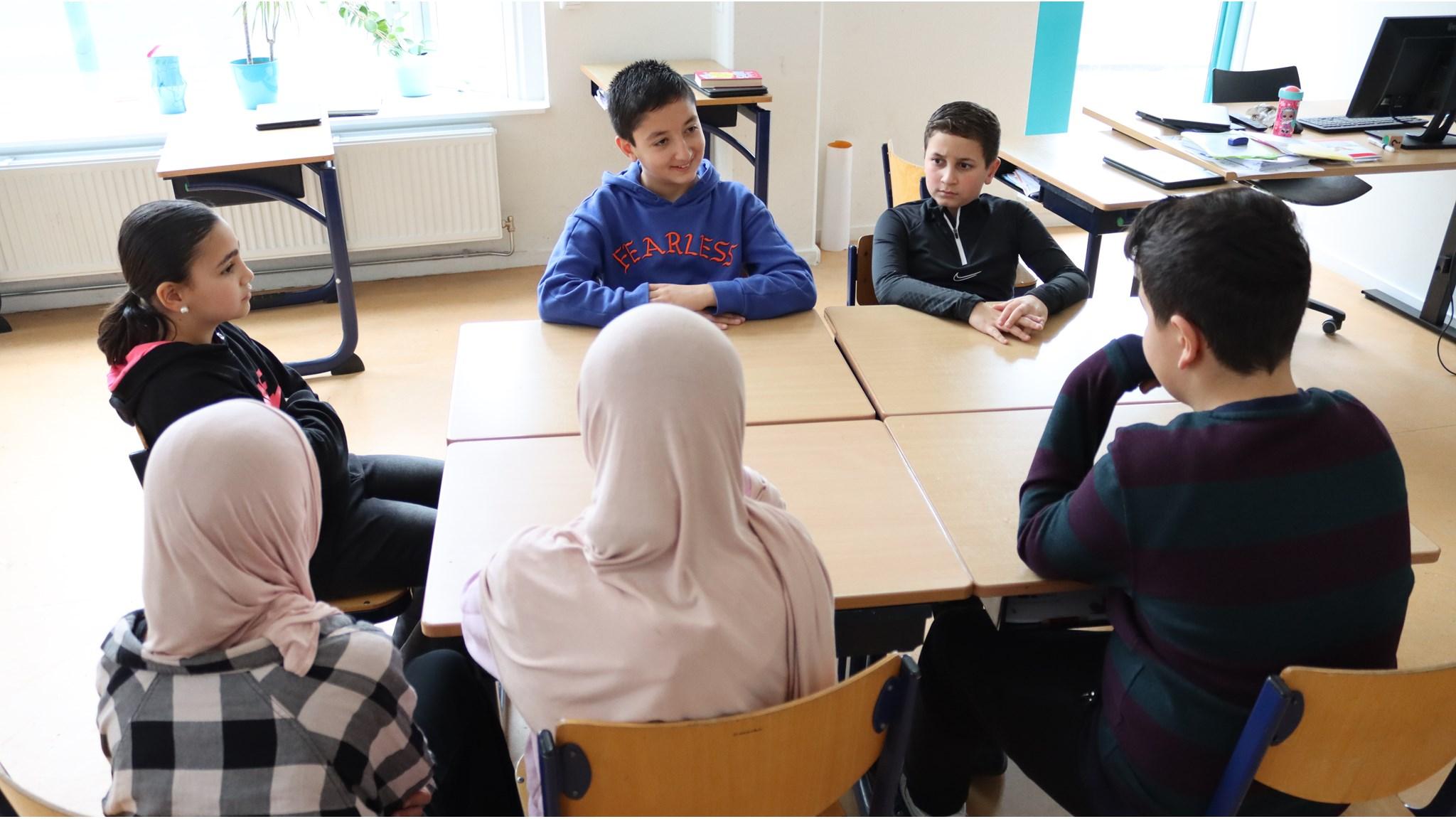 De leerlingen van De Zijderoute in Amsterdam zitten in de klas voor een groepsdiscussie. De leerlingen van De Zijderoute in Amsterdam zitten in de klas voor een groepsdiscussie.