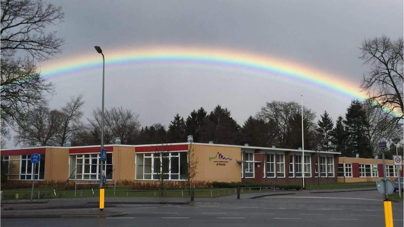 De Meander school in Nijverdal onder een kleurrijke regenboog.