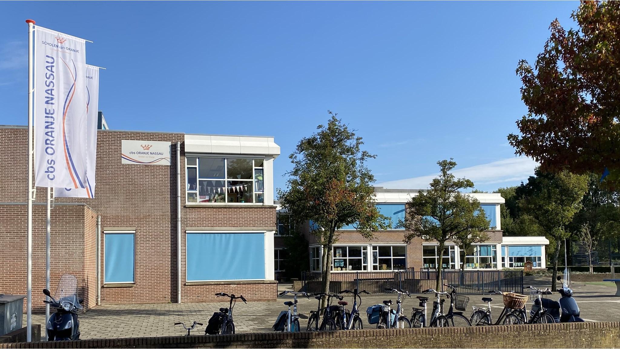 De voorzijde van de Oranje Nassauschool in Dordrecht met fietsenstalling en duidelijke schoolborden. De voorzijde van de Oranje Nassauschool in Dordrecht met fietsenstalling en duidelijke schoolborden.