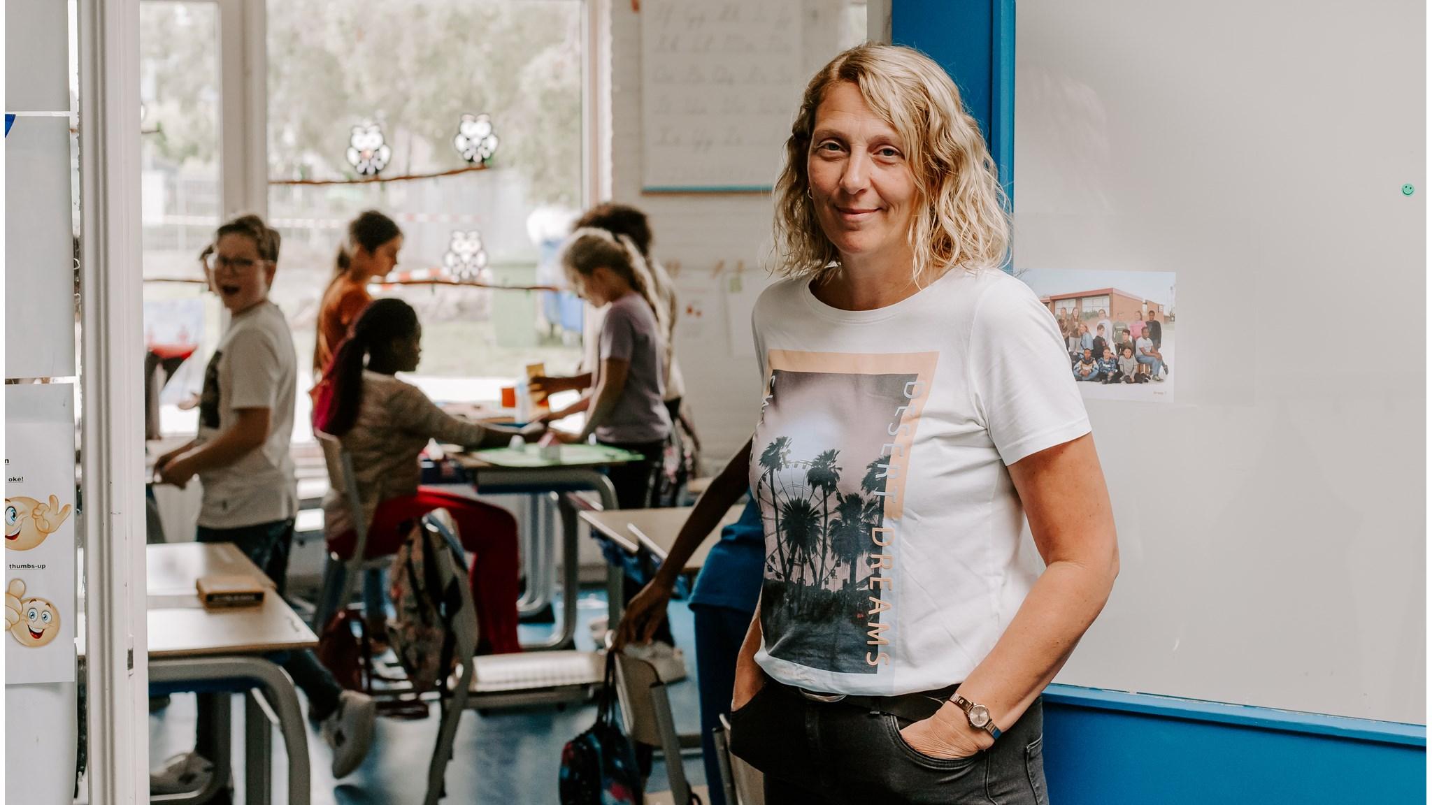 Deze afbeelding toont een docente van de Prinses Marijkeschool in Axel terwijl leerlingen in de klas aan het werk zijn. Deze afbeelding toont een docente van de Prinses Marijkeschool in Axel terwijl leerlingen in de klas aan het werk zijn.