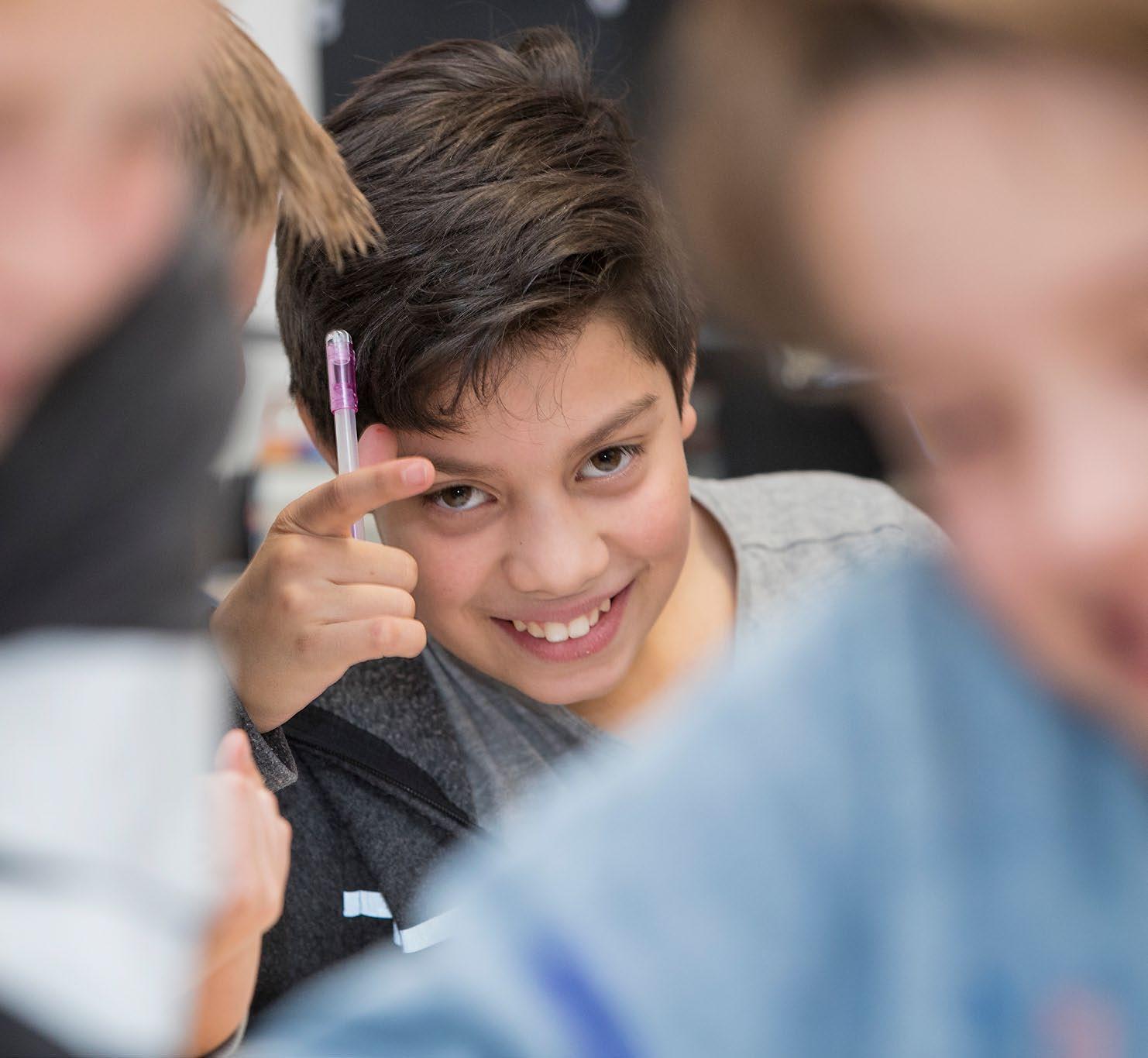 Deze afbeelding toont een glimlachende jongen in de klas van de Houtrustschool in Den Haag. Deze afbeelding toont een glimlachende jongen in de klas van de Houtrustschool in Den Haag.
