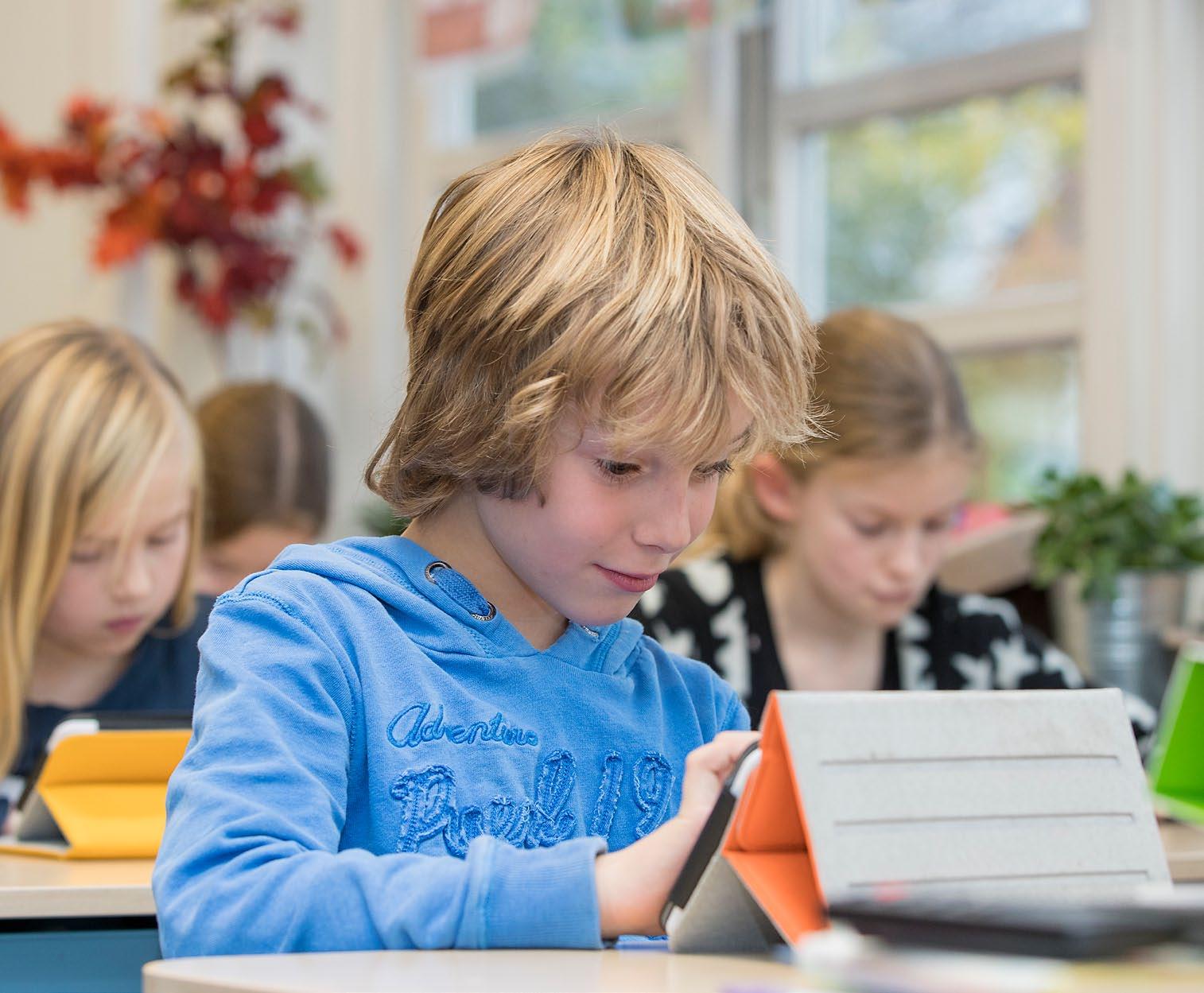 Dit is een afbeelding van leerlingen die geconcentreerd werken met tablets in de klas van de Houtrustschool in Den Haag. Dit is een afbeelding van leerlingen die geconcentreerd werken met tablets in de klas van de Houtrustschool in Den Haag.