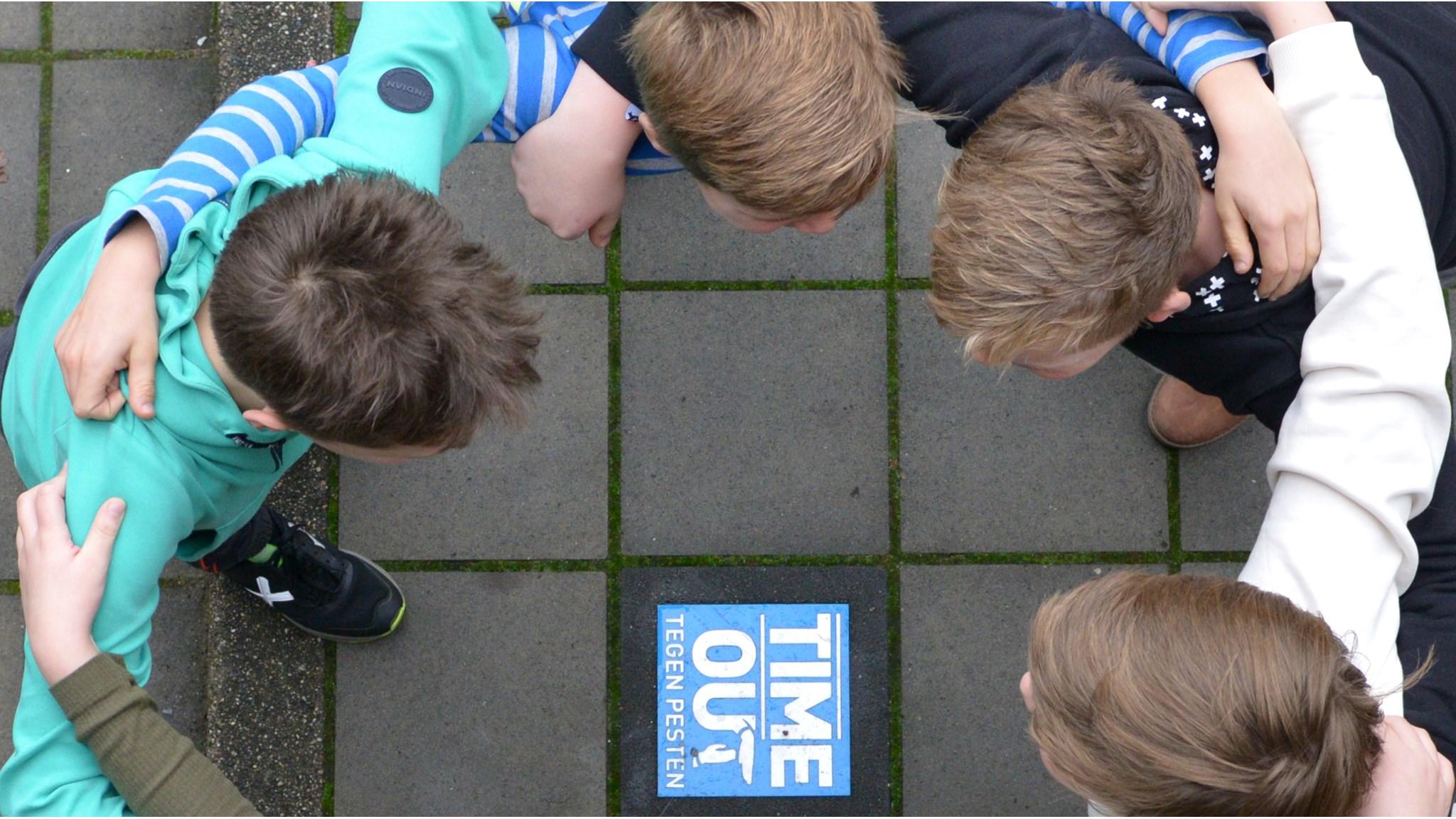 Dit is een afbeelding van leerlingen van de Mariaschool in Reutum die samenkomen rond het 'TIME OUT' bord tegen pesten op het schoolplein. Dit is een afbeelding van leerlingen van de Mariaschool in Reutum die samenkomen rond het 'TIME OUT' bord tegen pesten op het schoolplein.