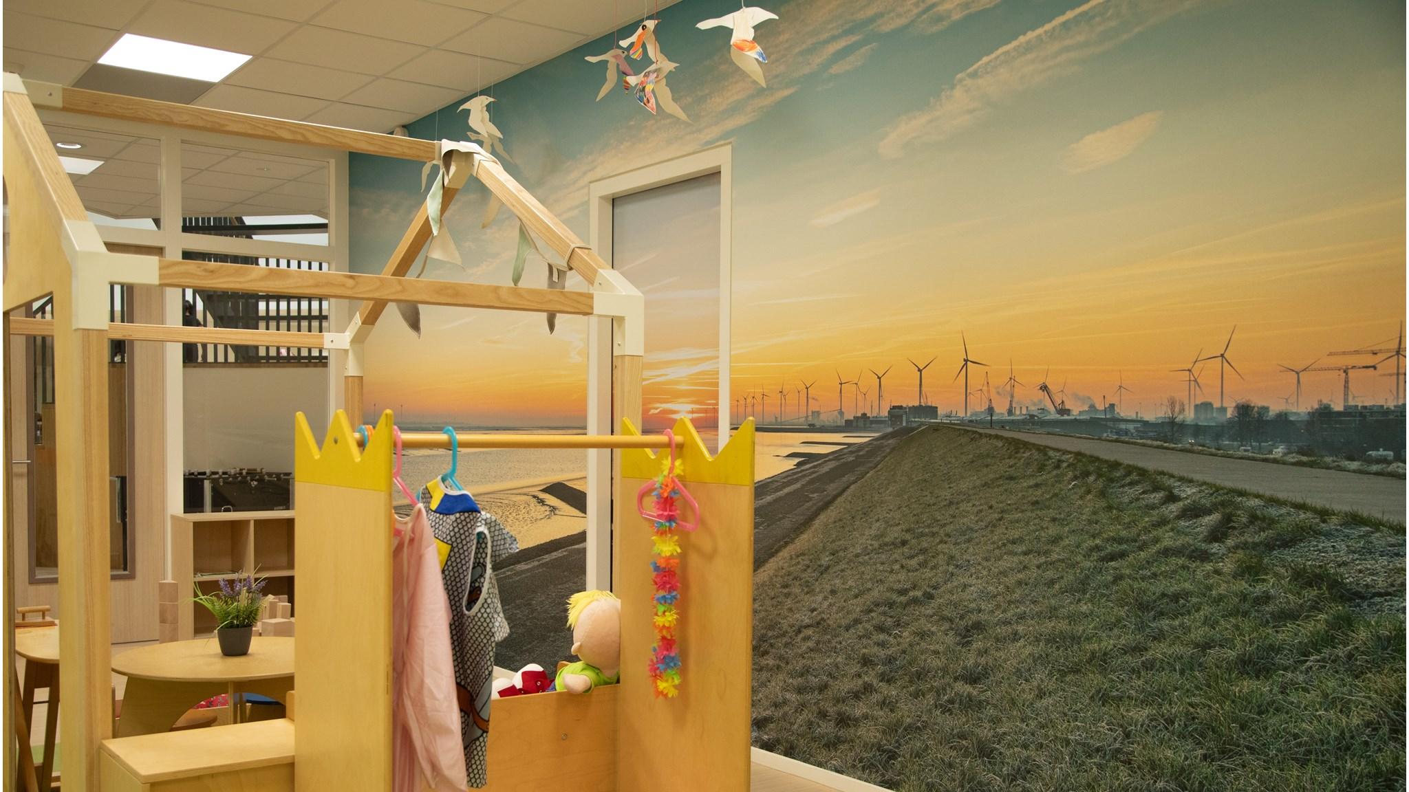 Dit is een kleurrijke speelhoek in CBS Ravelijn in Delfzijl met een grote muurschildering van een zonsopgang en windturbines. Dit is een kleurrijke speelhoek in CBS Ravelijn in Delfzijl met een grote muurschildering van een zonsopgang en windturbines.