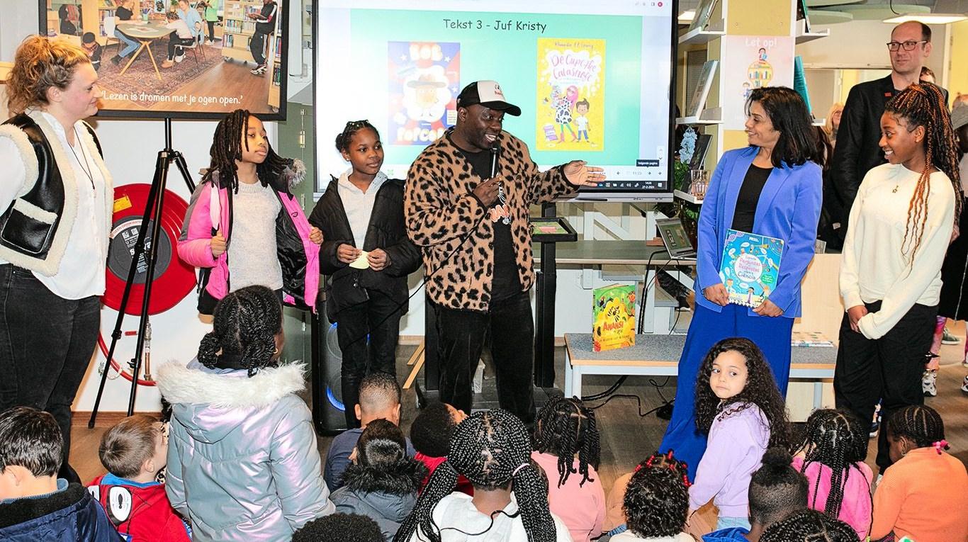 Diverse leerlingen van basisschool Bijlmerhorst in Amsterdam presenteren met enthousiasme tijdens een boekenweekactiviteit. Diverse leerlingen van basisschool Bijlmerhorst in Amsterdam presenteren met enthousiasme tijdens een boekenweekactiviteit.