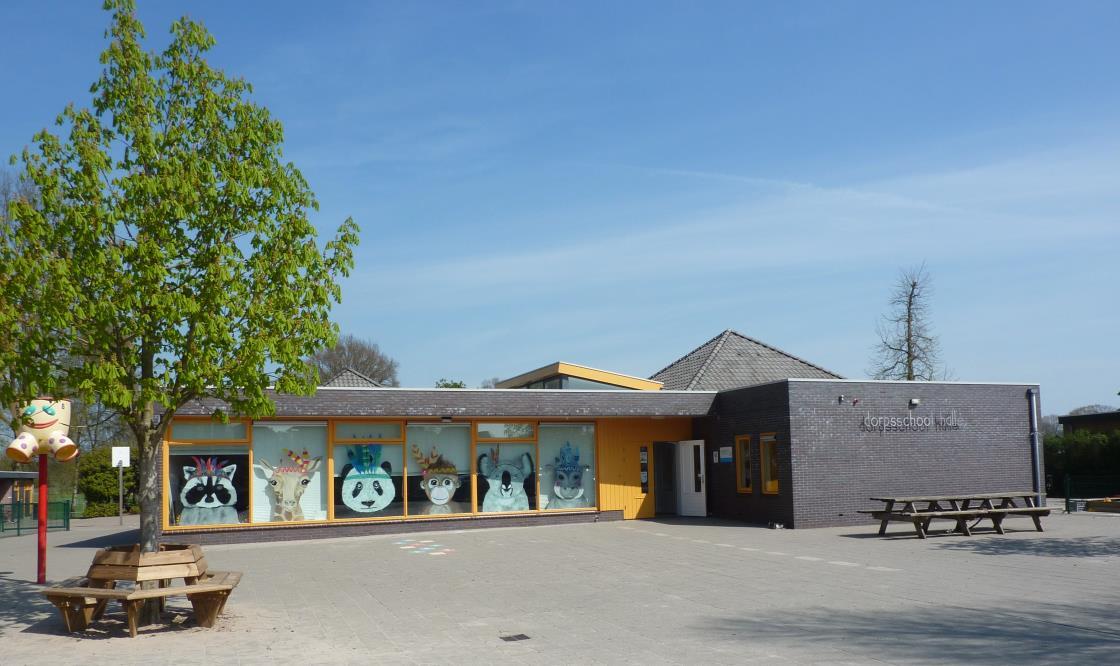 Dorpsschool Halle met kleurrijke kunstwerken op de ramen en een uitnodigende schoolplein. Dorpsschool Halle met kleurrijke kunstwerken op de ramen en een uitnodigende schoolplein.