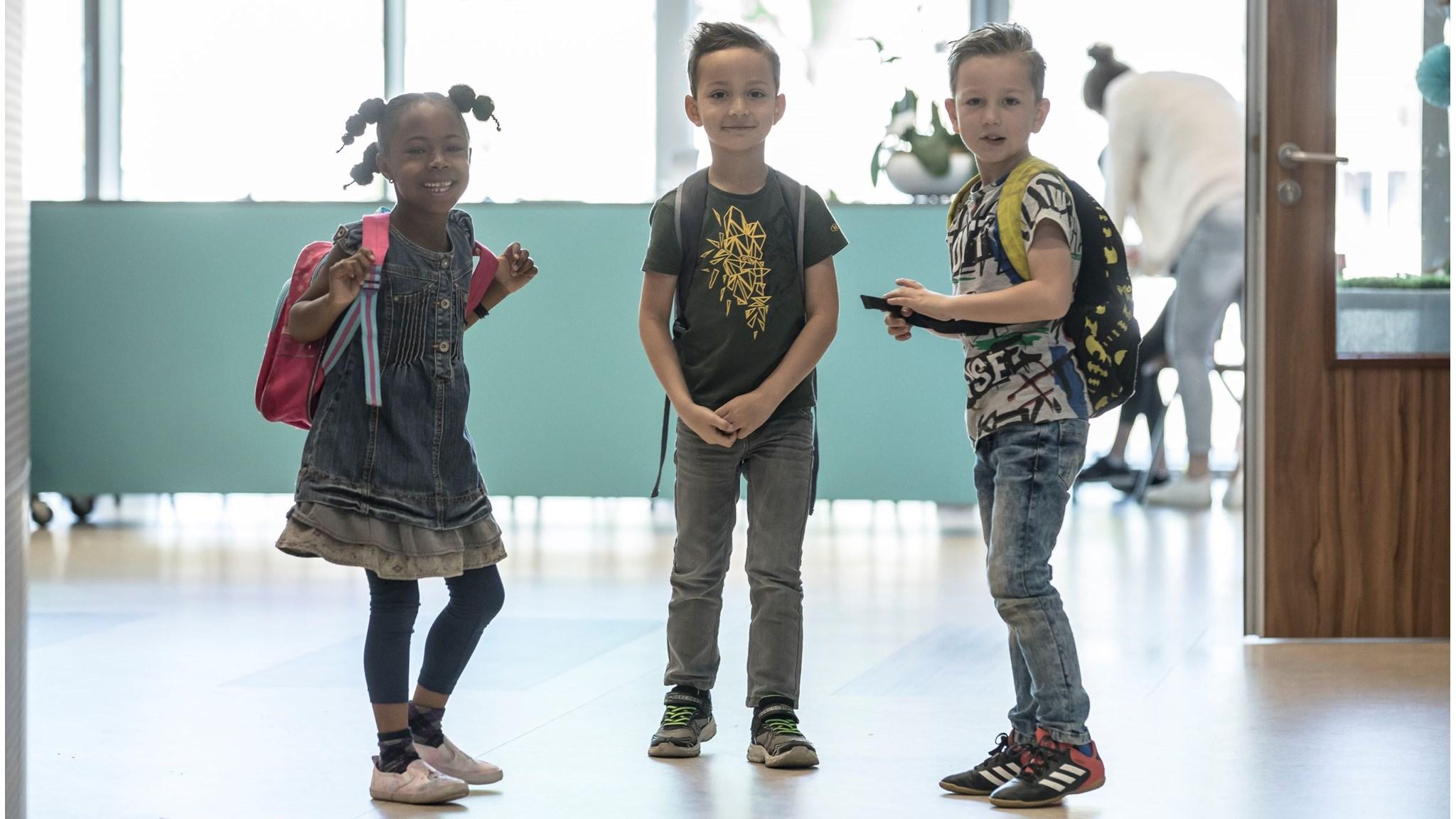 Drie blije kinderen poseerden in de hal van Basisschool de Vijfmaster in Veghel. Drie blije kinderen poseerden in de hal van Basisschool de Vijfmaster in Veghel.