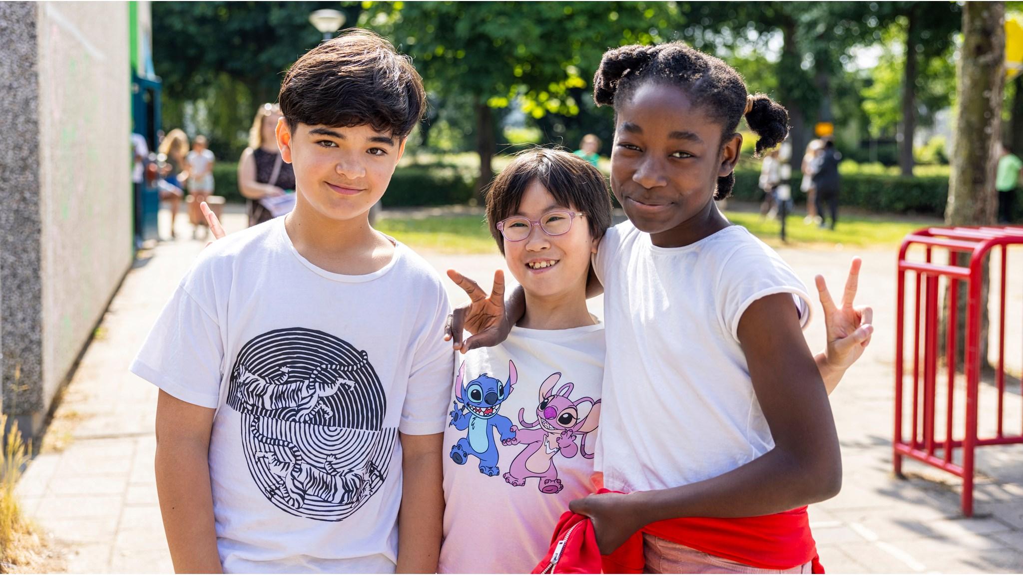 Drie blije kinderen poseren samen op het schoolplein van SBO De Watertuin in Almere. Drie blije kinderen poseren samen op het schoolplein van SBO De Watertuin in Almere.