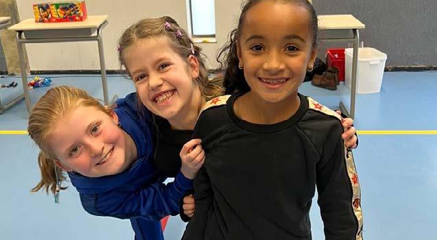 Drie blije kinderen van de Prins Mauritsschool in Delft poseren samen. Drie blije kinderen van de Prins Mauritsschool in Delft poseren samen.
