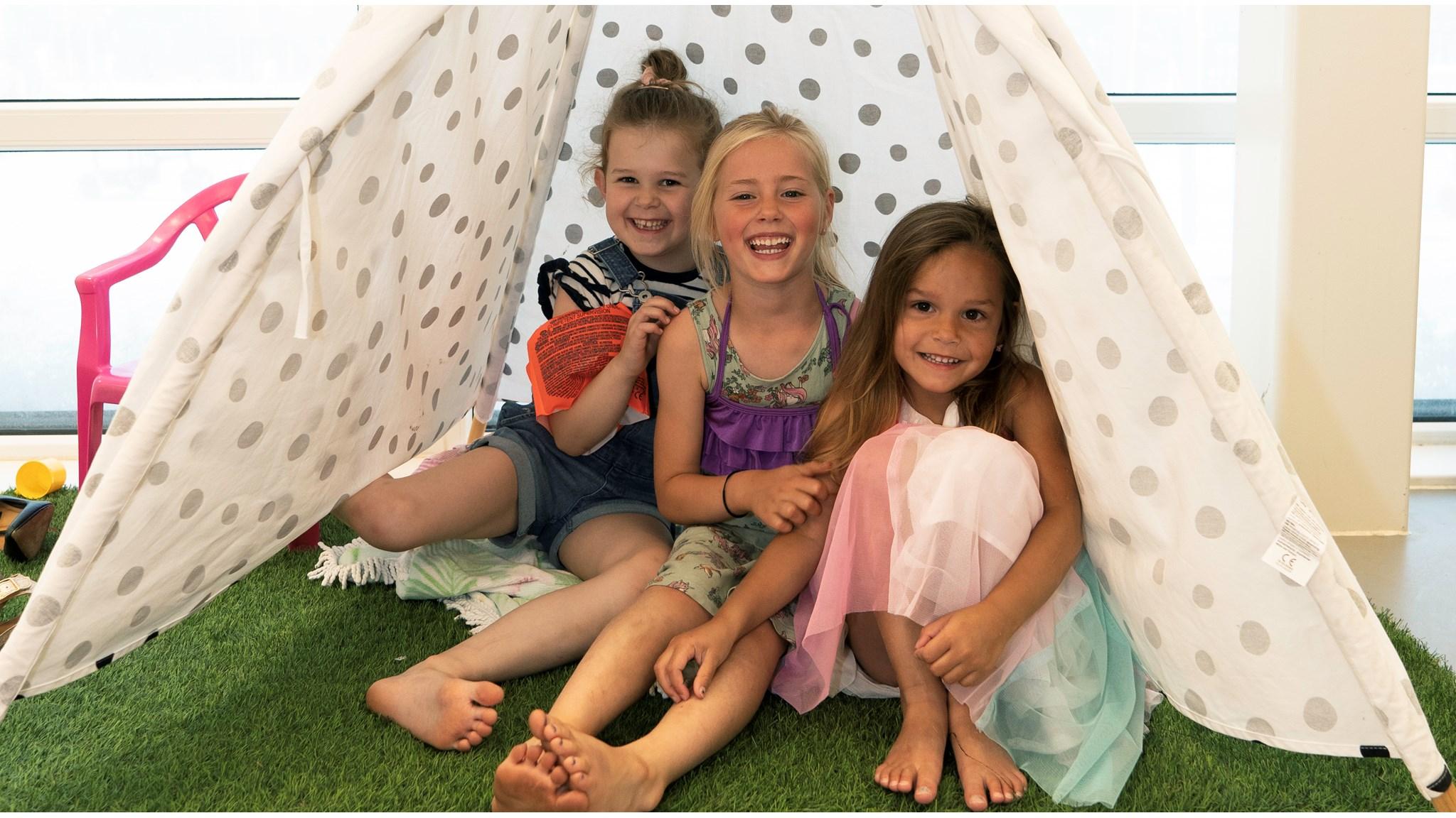 Drie blije kinderen zitten samen in een speelhuisje op KC Koningskwartier in Zevenhuizen (Zuid-Holland). Drie blije kinderen zitten samen in een speelhuisje op KC Koningskwartier in Zevenhuizen (Zuid-Holland).