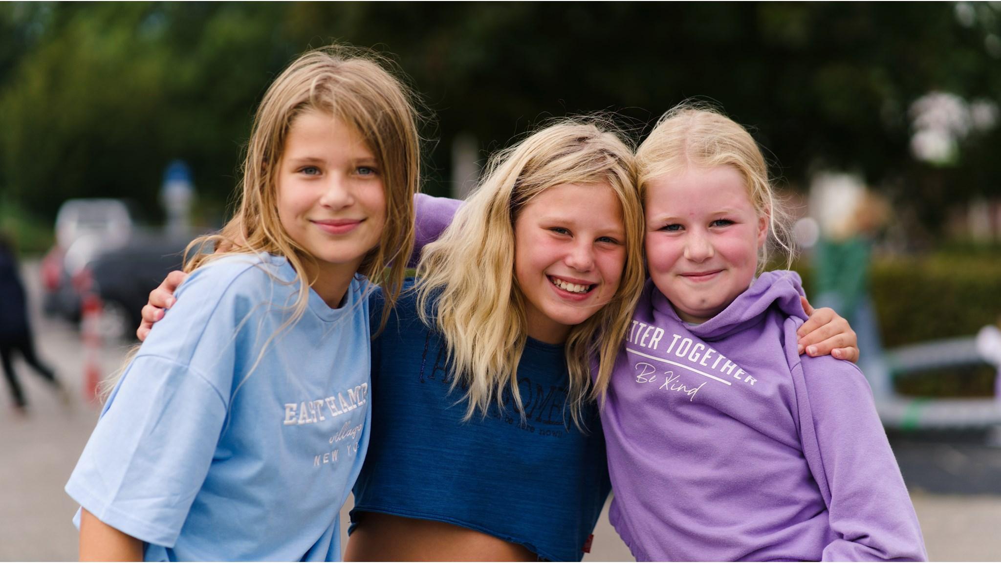 Drie blije meisjes op het schoolplein van Openbare Basisschool Flevosprong in Dronten. Drie blije meisjes op het schoolplein van Openbare Basisschool Flevosprong in Dronten.