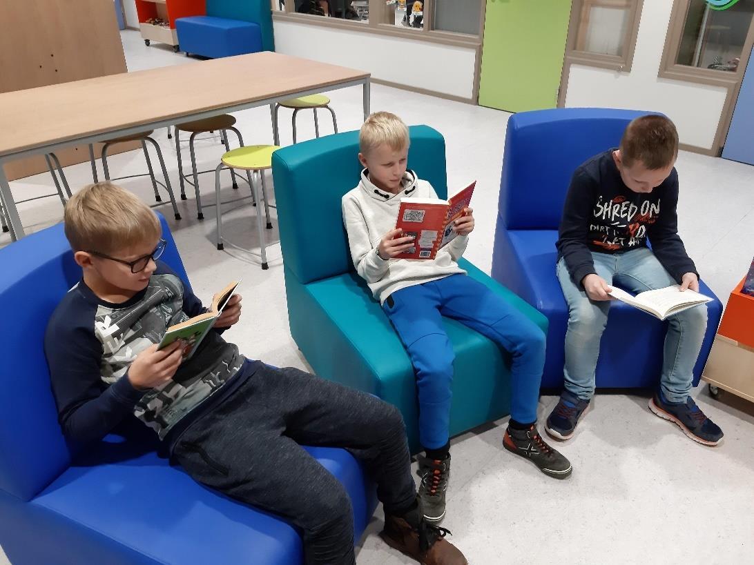 Drie kinderen lezen boeken in de leeshoek van basisschool Waadwizer in Tzummarum. Drie kinderen lezen boeken in de leeshoek van basisschool Waadwizer in Tzummarum.