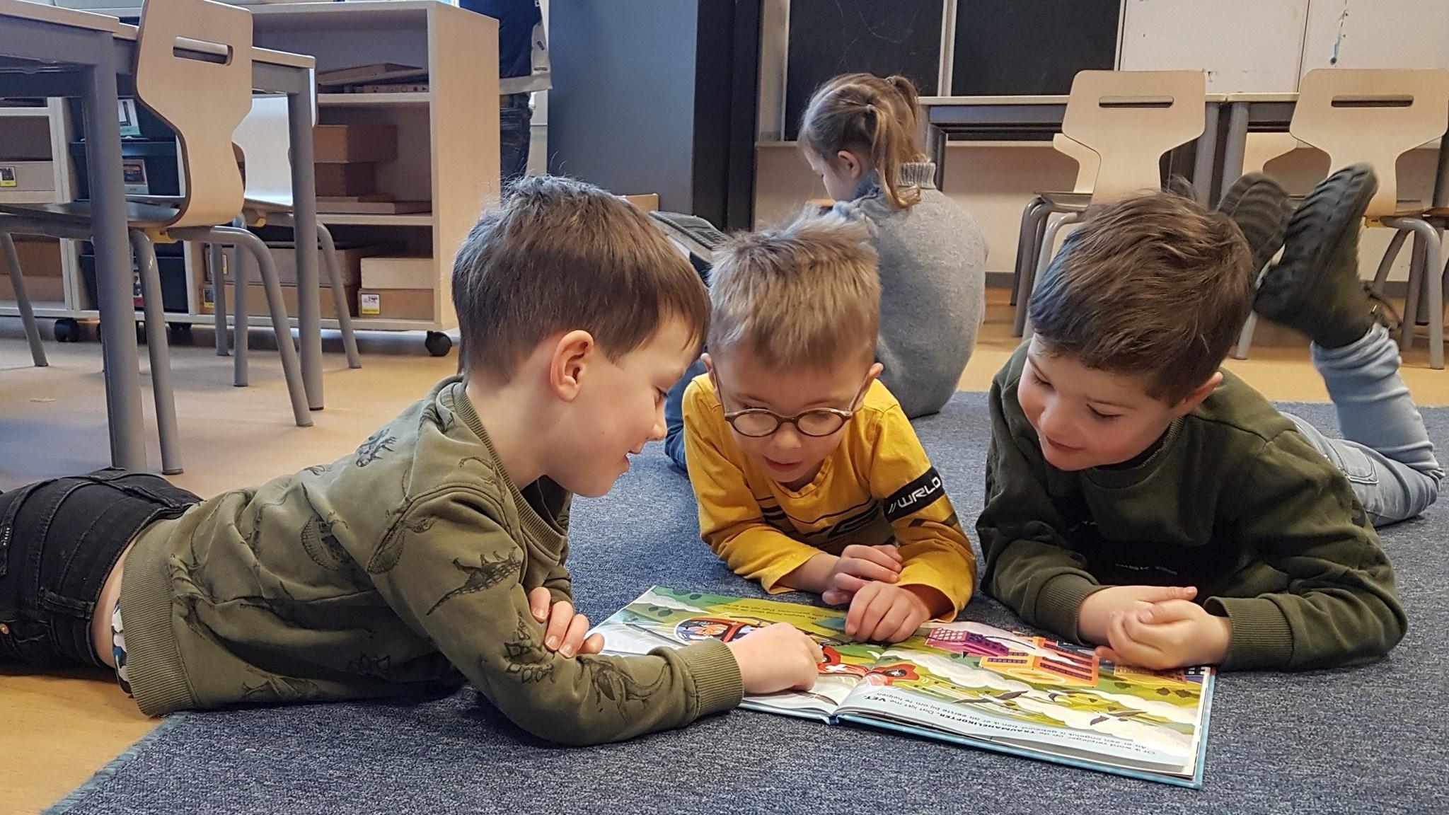 Drie kinderen lezen samen een boek in de klas van Basisschool Maria in Erp. Drie kinderen lezen samen een boek in de klas van Basisschool Maria in Erp.