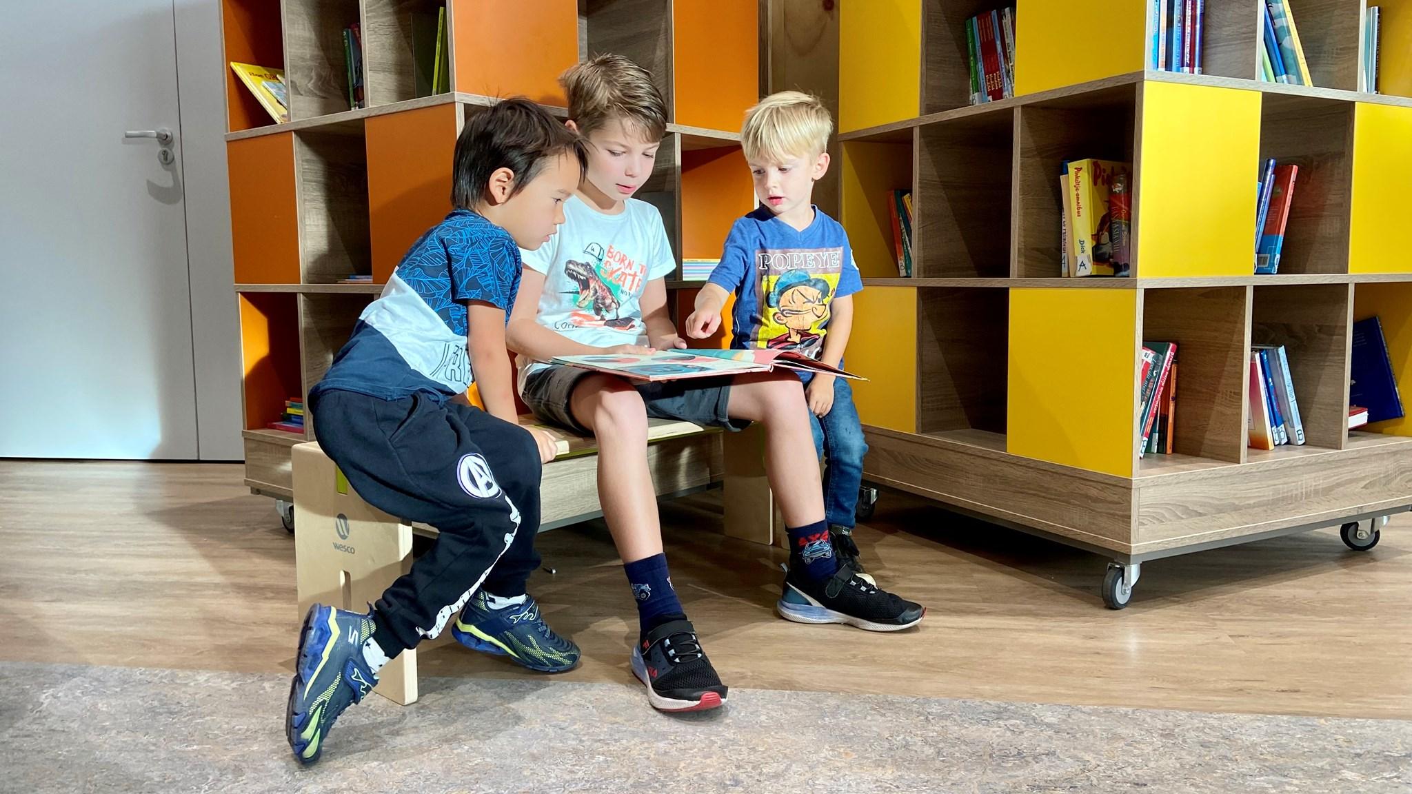 Drie kinderen lezen samen een boek in KindCentrum Altweerterheide in Weert. Drie kinderen lezen samen een boek in KindCentrum Altweerterheide in Weert.
