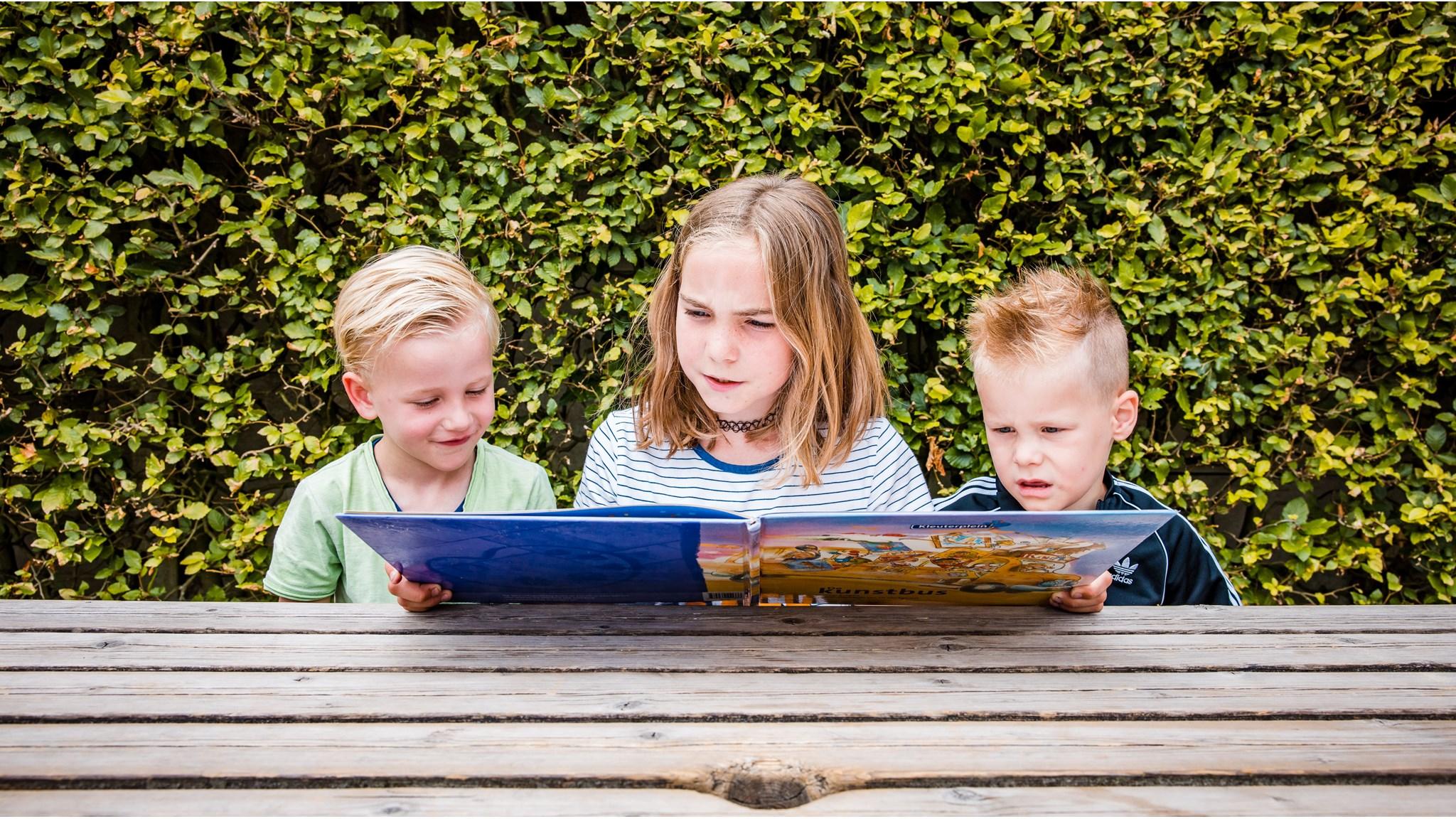 Drie kinderen lezen samen een boek op het schoolplein van De Wheemschool in Voorthuizen. Drie kinderen lezen samen een boek op het schoolplein van De Wheemschool in Voorthuizen.