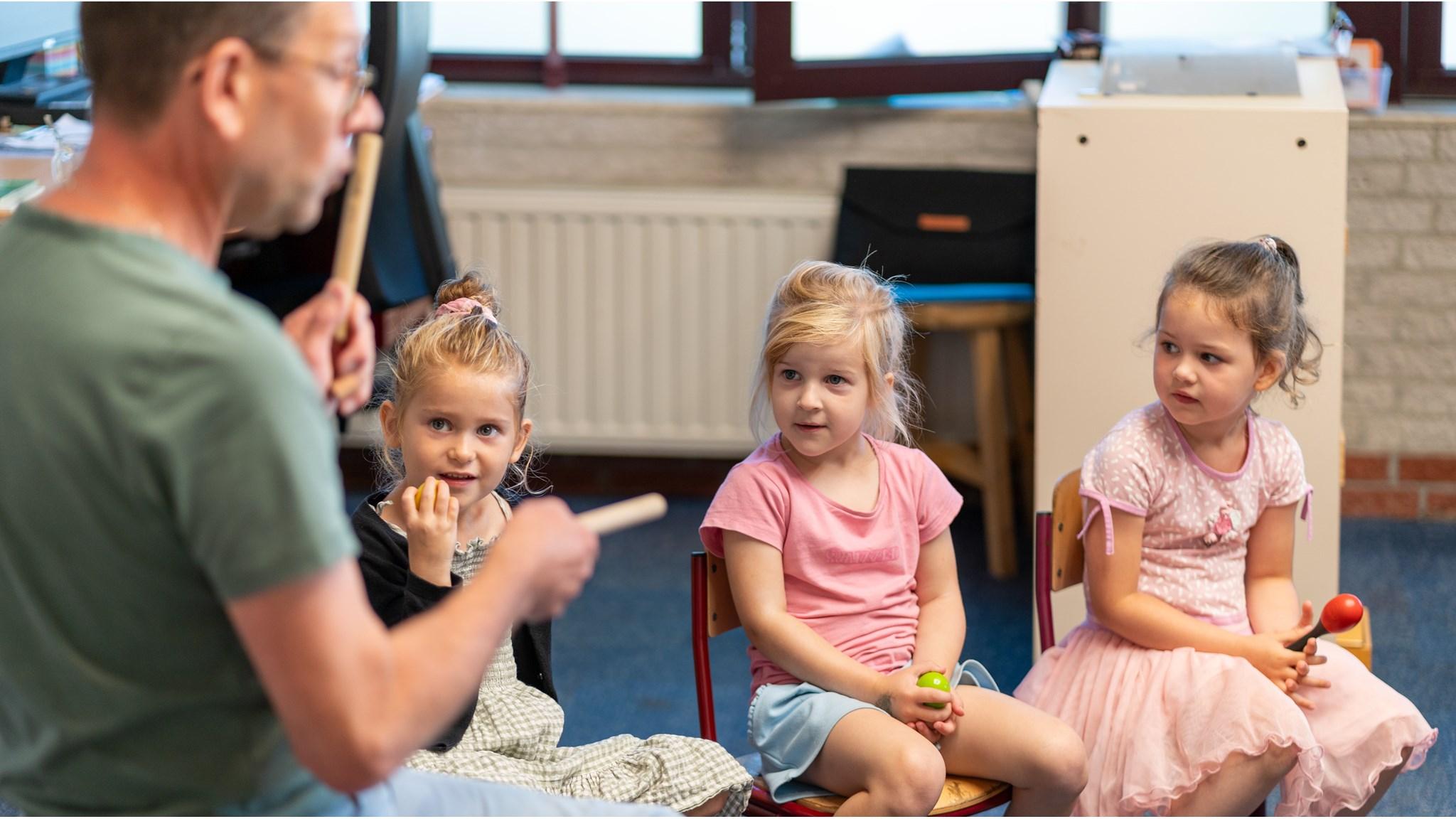 Drie kinderen luisteren aandachtig naar een leraar tijdens een muziekles op de Mariaschool in Pijnacker. Drie kinderen luisteren aandachtig naar een leraar tijdens een muziekles op de Mariaschool in Pijnacker.