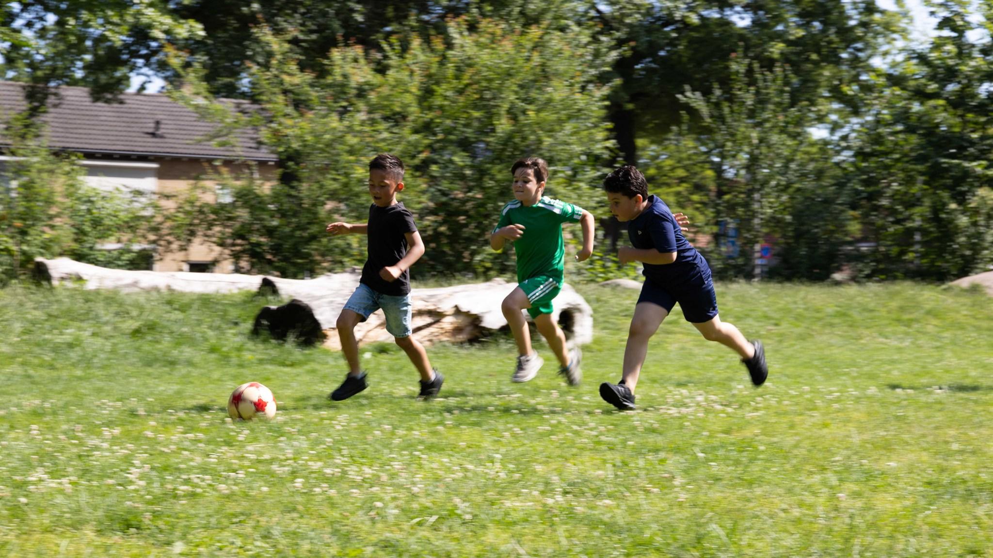 Drie kinderen rennen achter een voetbaltje op het schoolplein van Basisschool Baardwijk in Waalwijk. Drie kinderen rennen achter een voetbaltje op het schoolplein van Basisschool Baardwijk in Waalwijk.